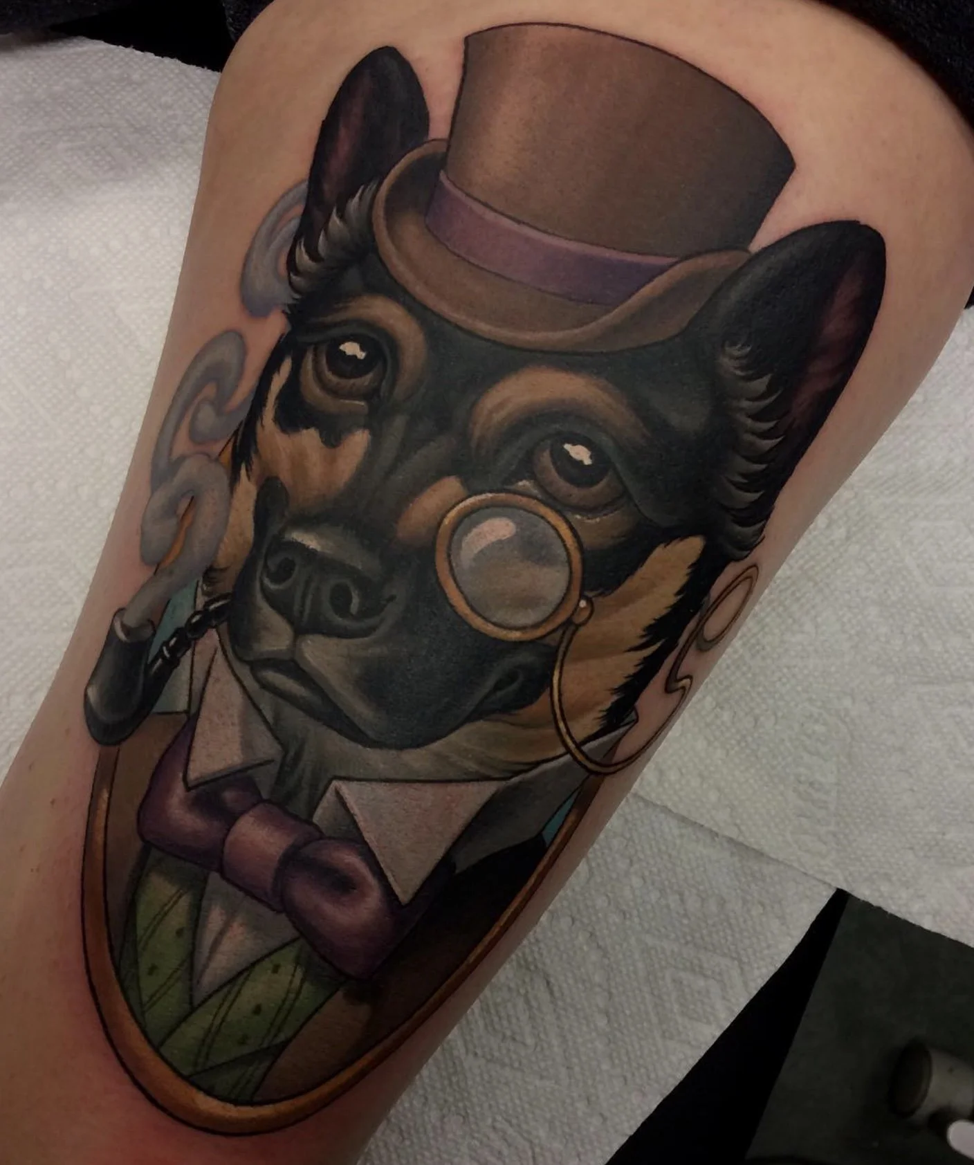 Colorful tattoo of a dog with a hat, nose ring, and cigar.