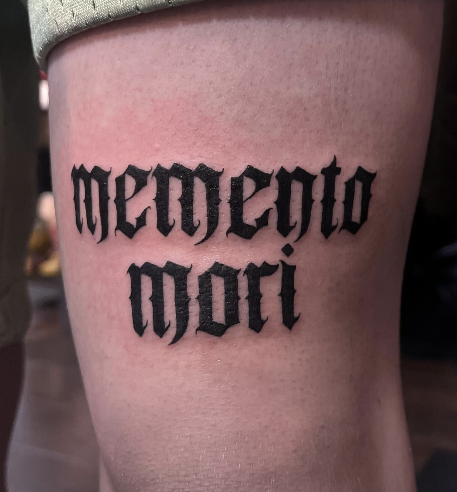 Tattoo on a person's side with black Gothic-style text that reads, 'accept'. 