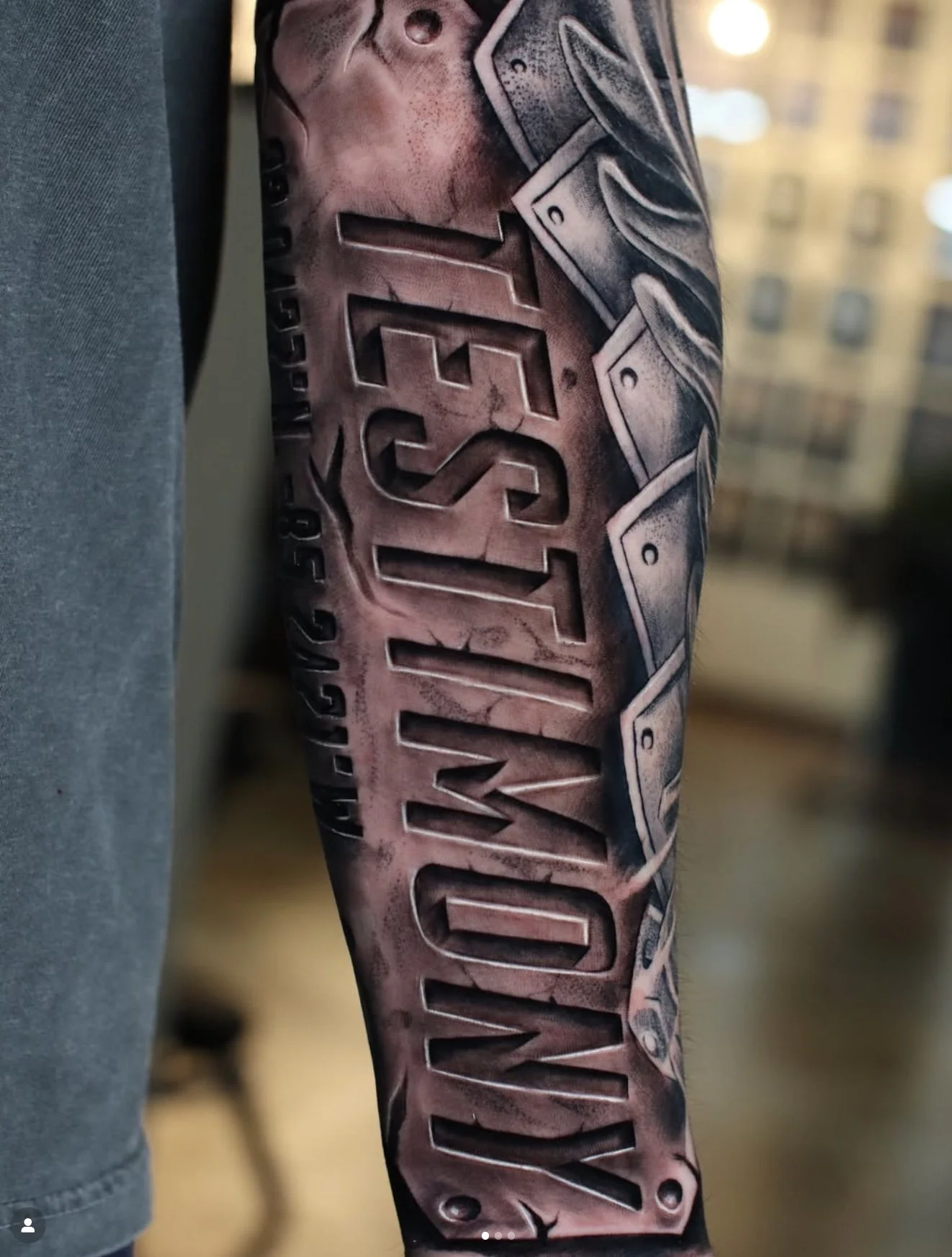 Close-up of a person's arm with a detailed tattoo of a metallic mechanical design and the text 'CHALLENGE' in large letters.