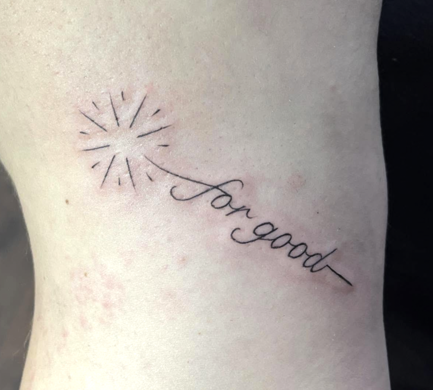 Tattoo of a dandelion with seeds blowing in the wind, accompanied by the cursive phrase "run good."