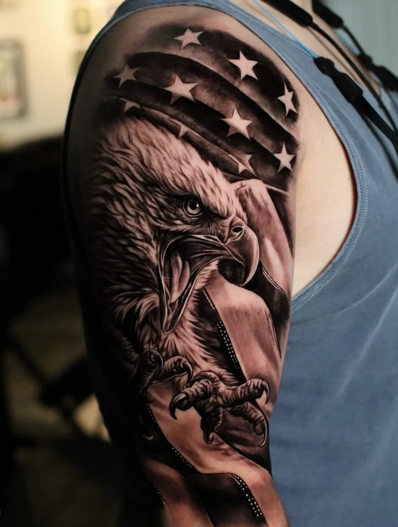 Tattoo of a bear in front of an American flag on a person's upper arm.