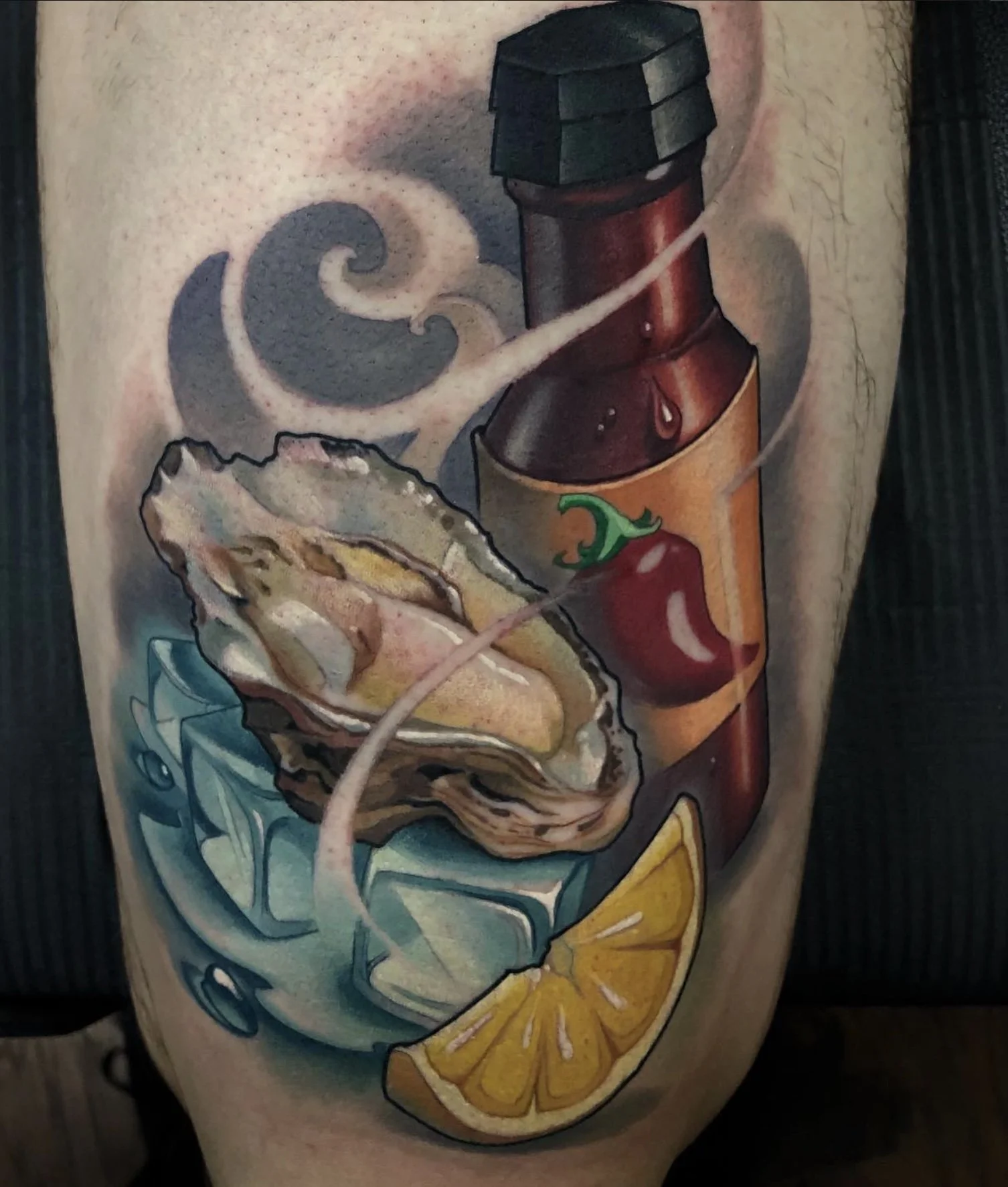 Tattoo of a bottle of hot sauce, a half shell oyster with oyster meat, ice cubes, and a lemon wedge on a person's arm.
