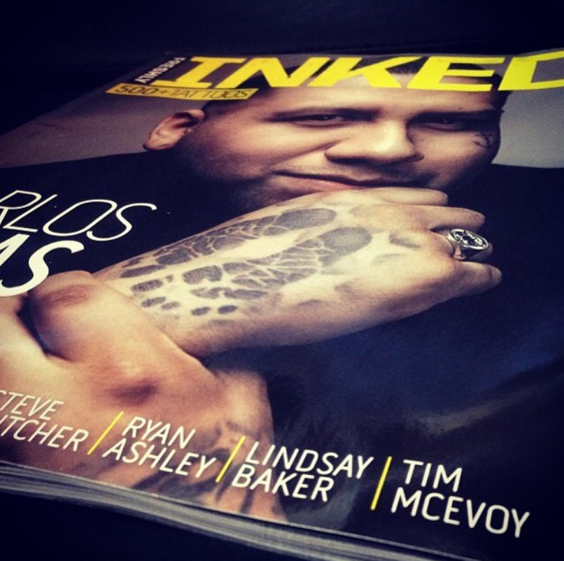 Close-up of a magazine cover featuring a person with a tattooed hand resting on their face, with bold yellow and white text and the names Steve Fletcher, Ryan Ashley, Lindsay Baker, and Tim McEvoy at the bottom.