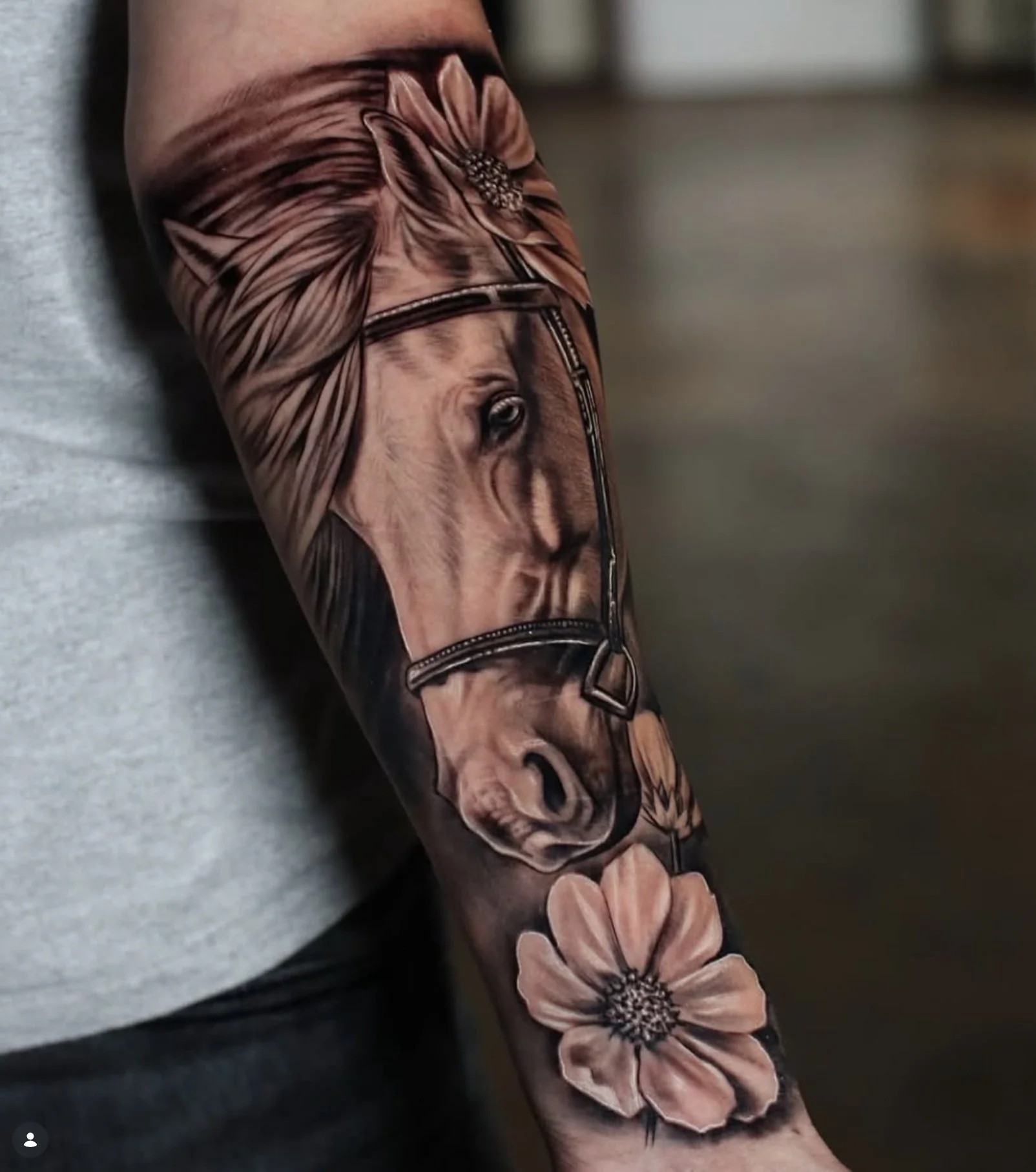 Tattoo of a horse's face and flowers on a person's arm.