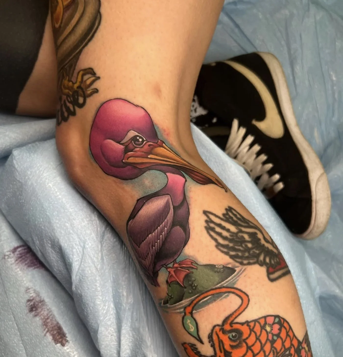 Colorful tattoo of a pink flamingo on a person's arm.