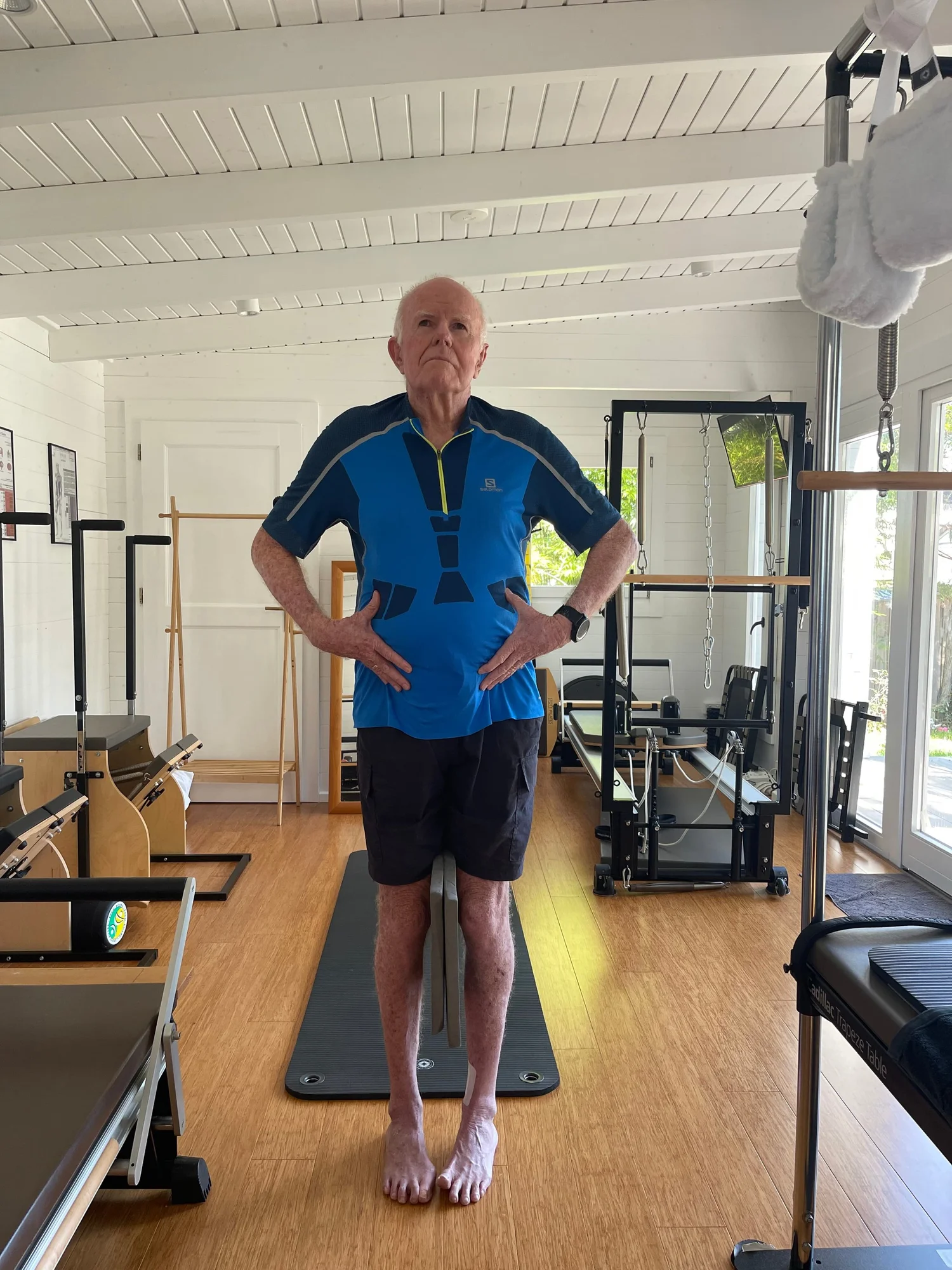 Client standing on a mat while Jill assesses his posture