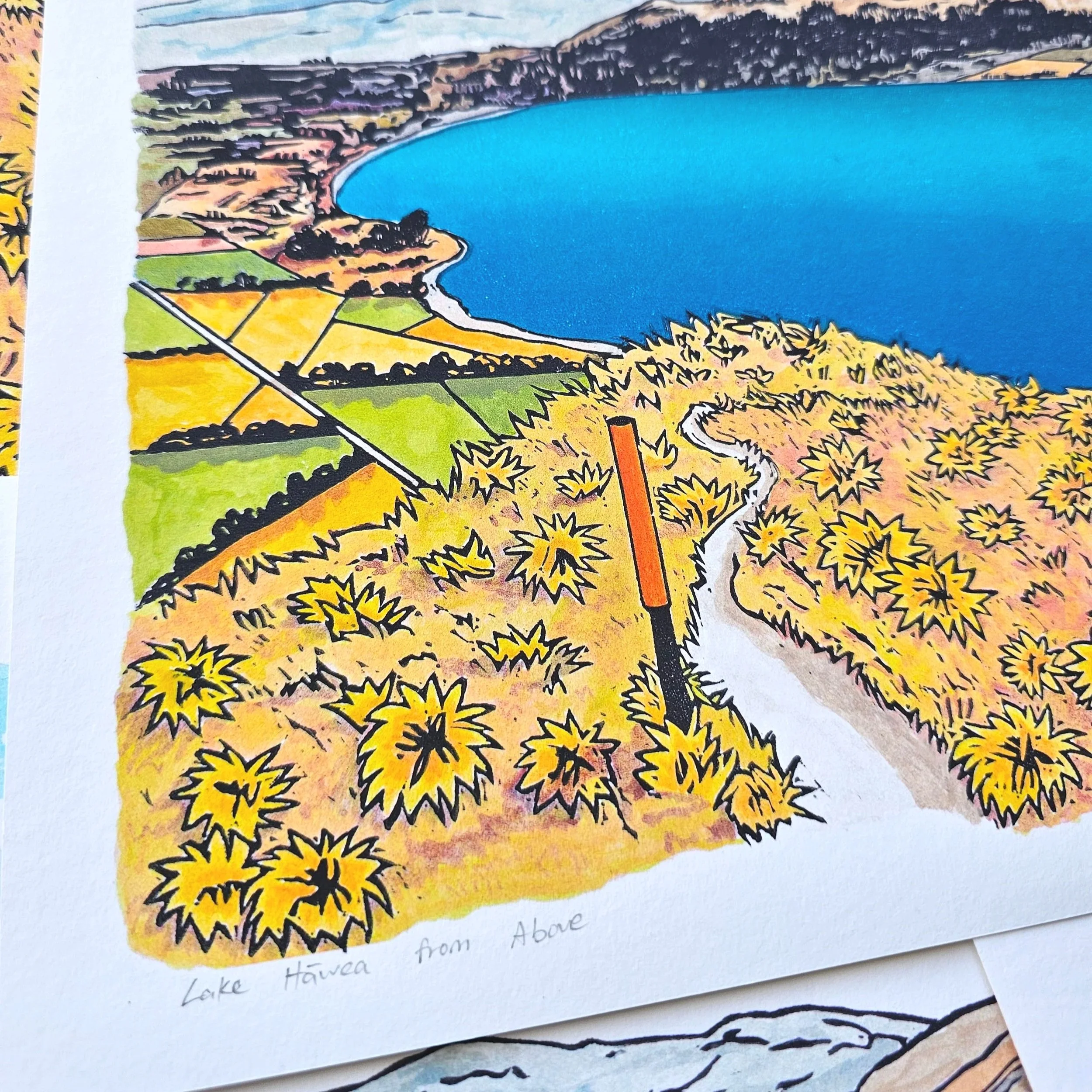 A colourful giclee print of a blue lake hawea with mountains and hills surrounding.