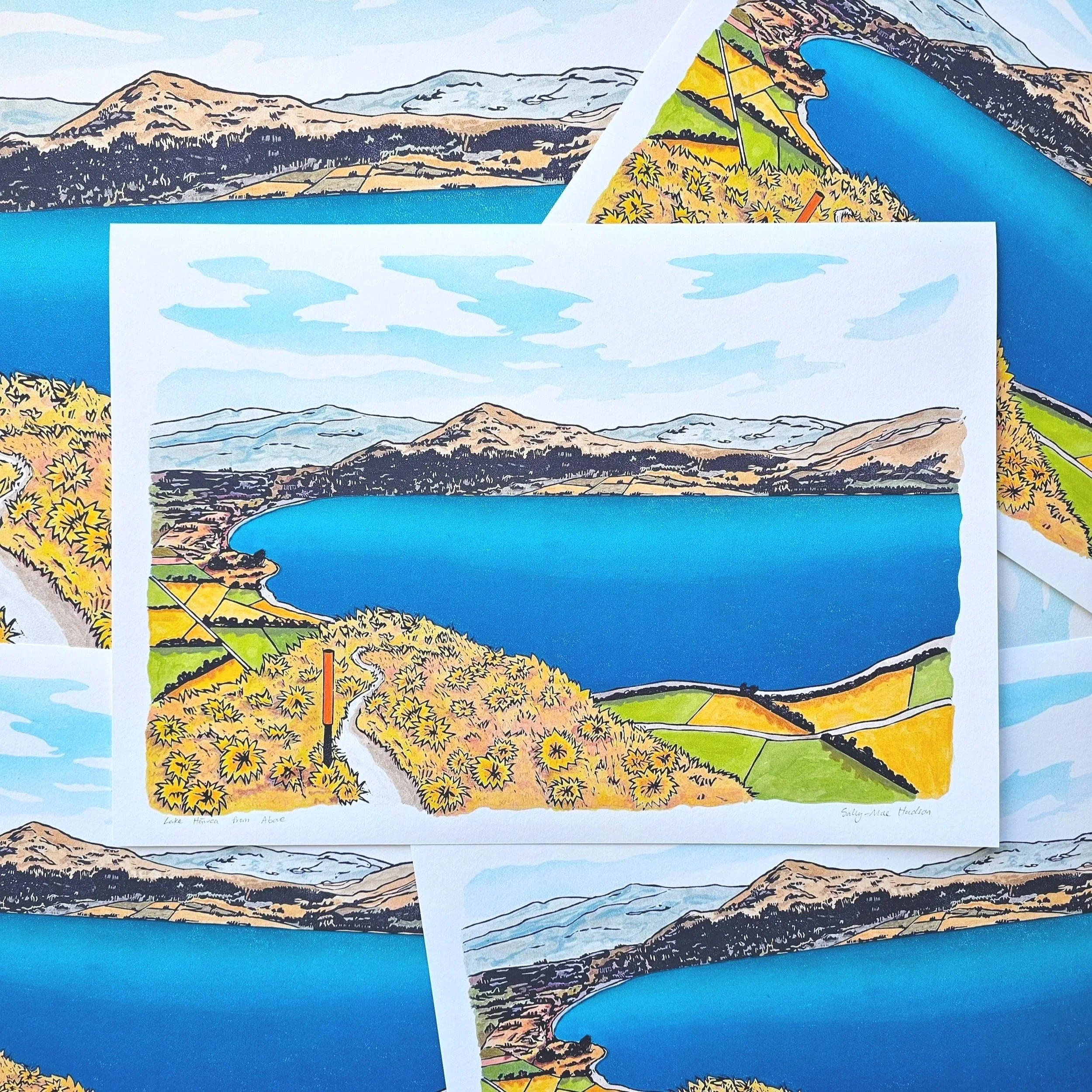 A colourful giclee print of a blue lake hawea with mountains and hills surrounding.