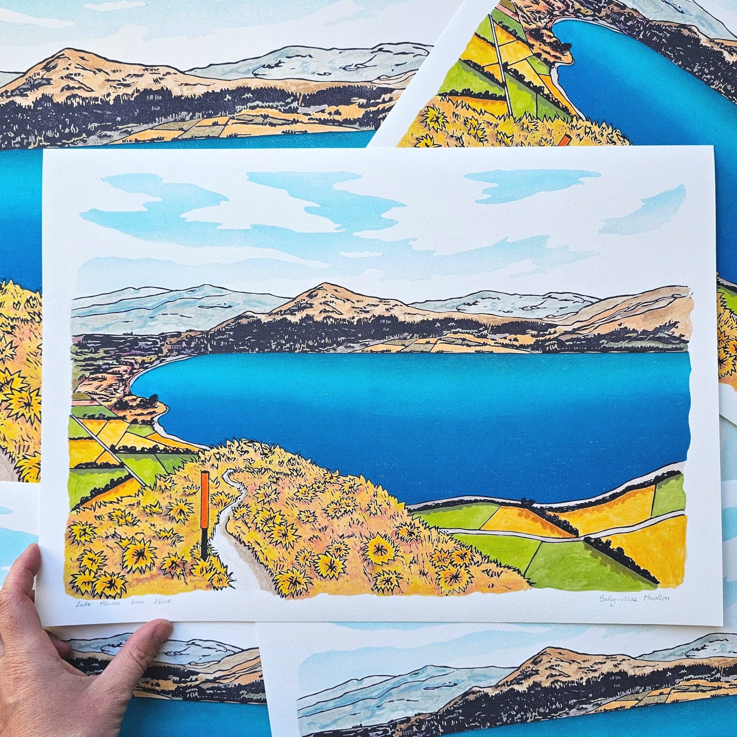 A colourful giclee print of a blue lake hawea with mountains and hills surrounding.