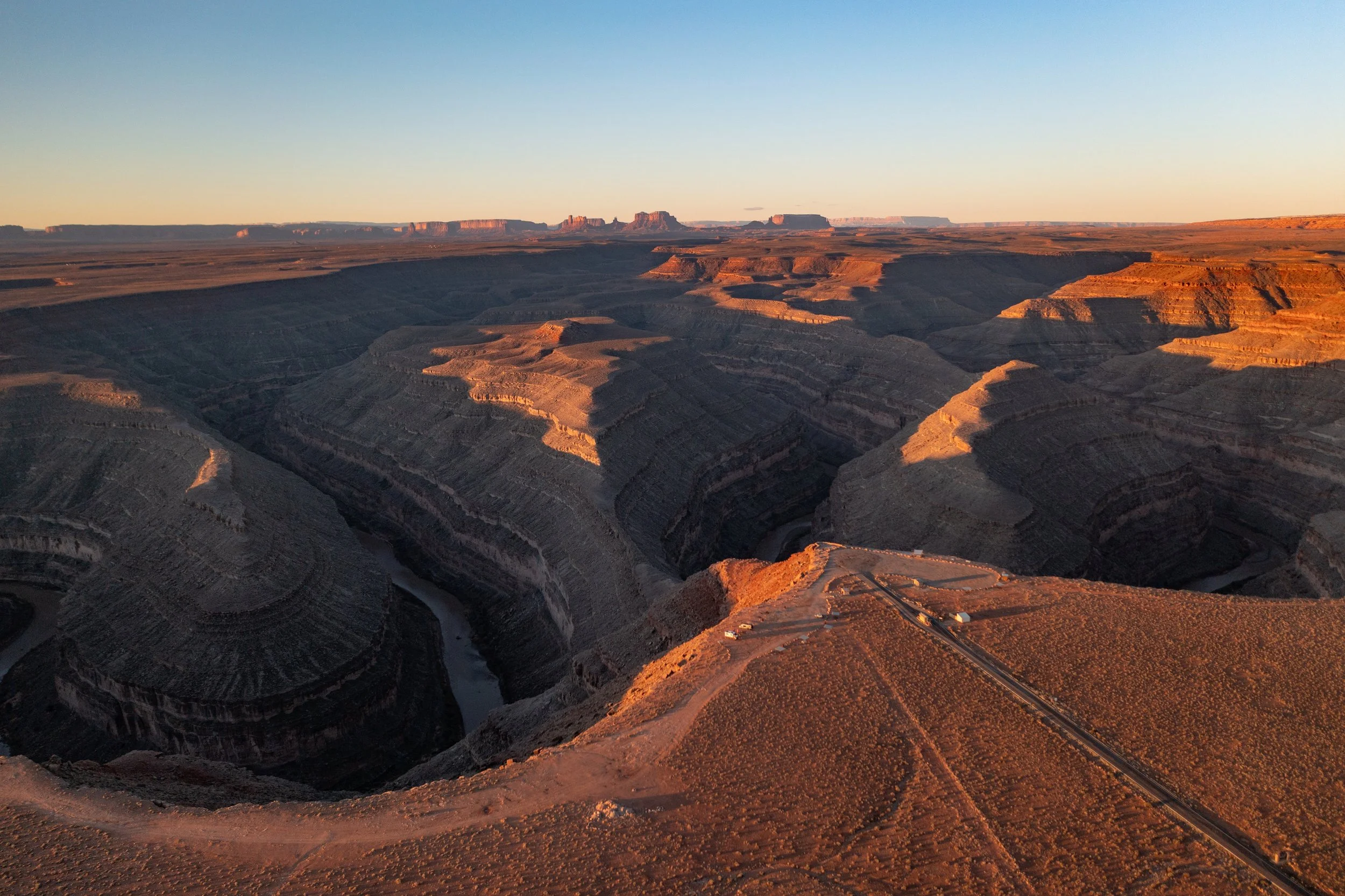 Sunset over the Goosenecks State park showcasing layered rock formations and deep valleys.