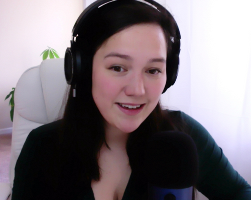 Michelle Yue, an urban puppy specialist, with long dark hair wearing headphones and speaking into a microphone in a home studio.