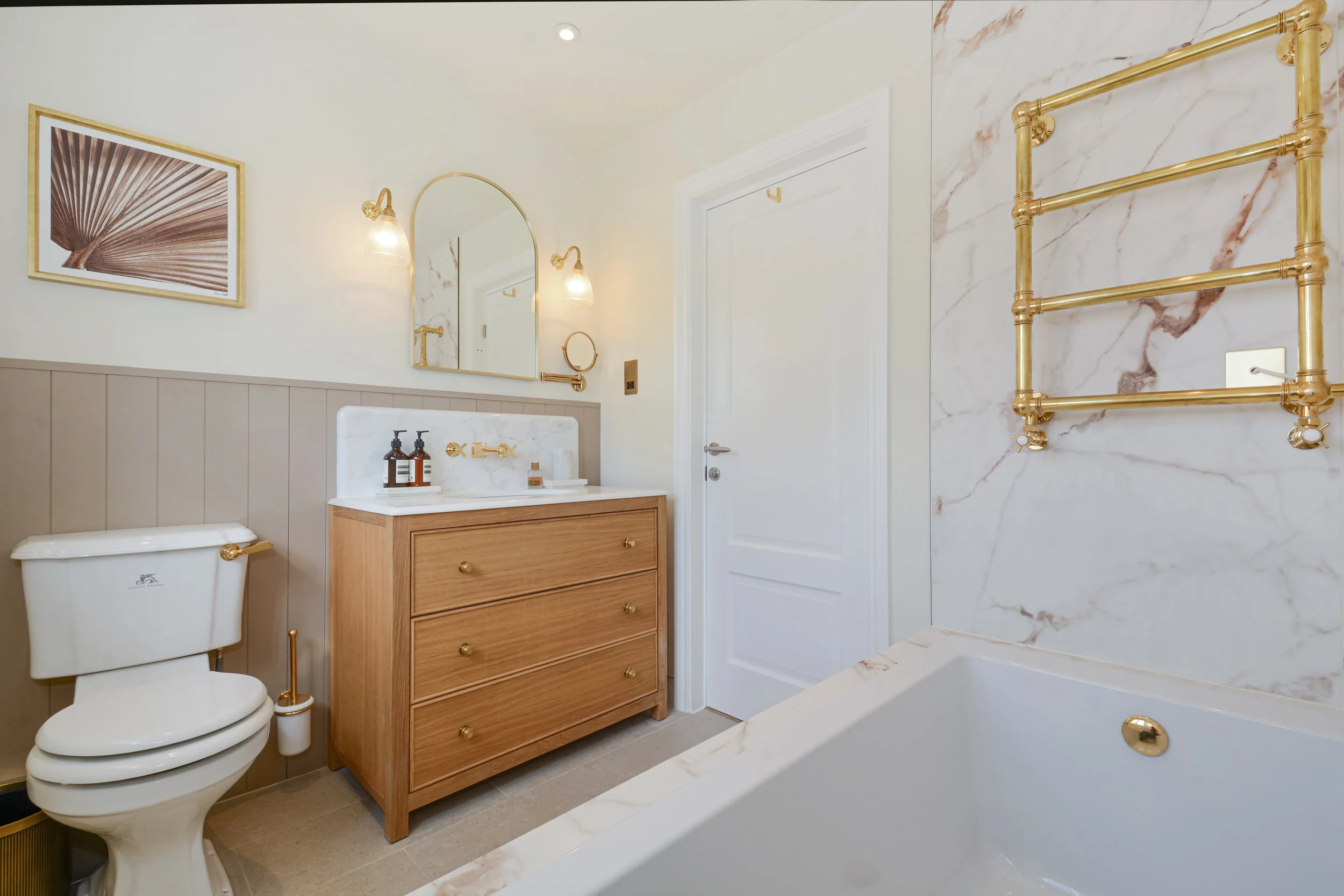 The family bathroom mixes large format marble effect porcelain slabs with tongue and groove panels