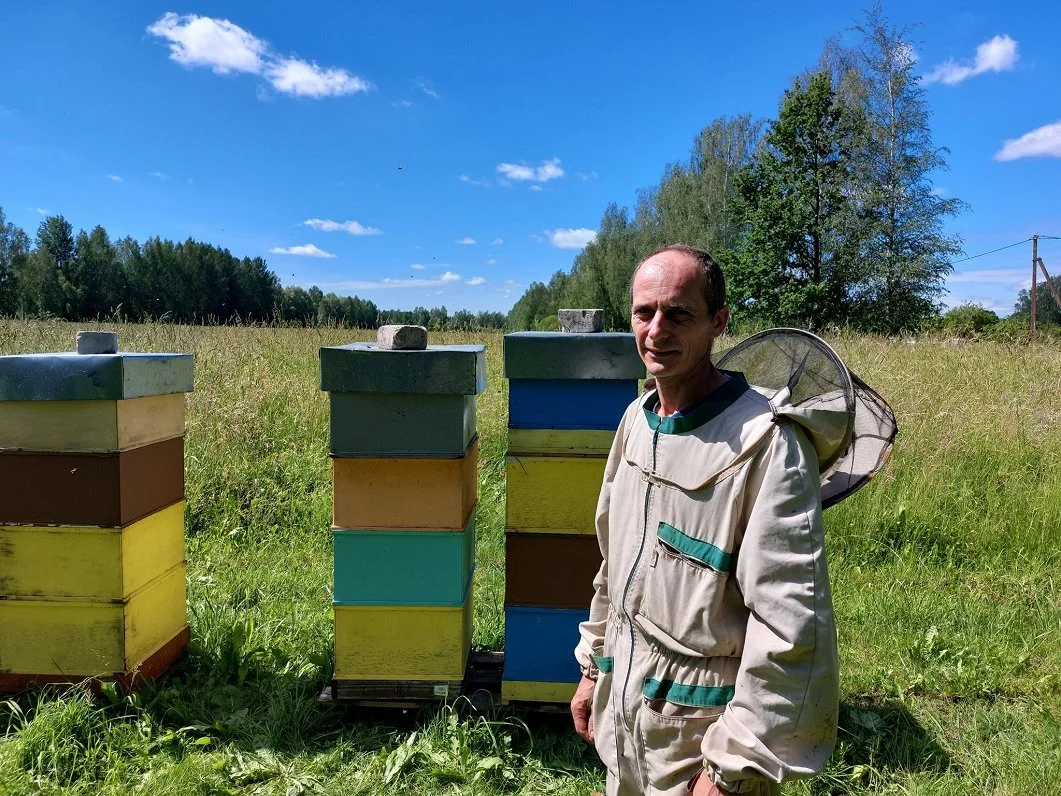 beekeeper standing by beehives