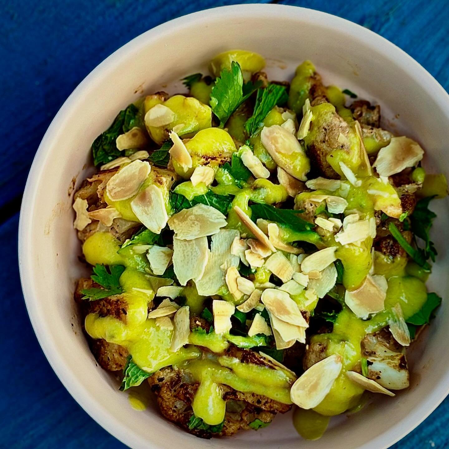 GRIDDLED CAULIFLOWER marinated in black harissa yogurt and dressed with turmeric pickled golden raisins, almonds and herbs. 🍁 🍂 🍁