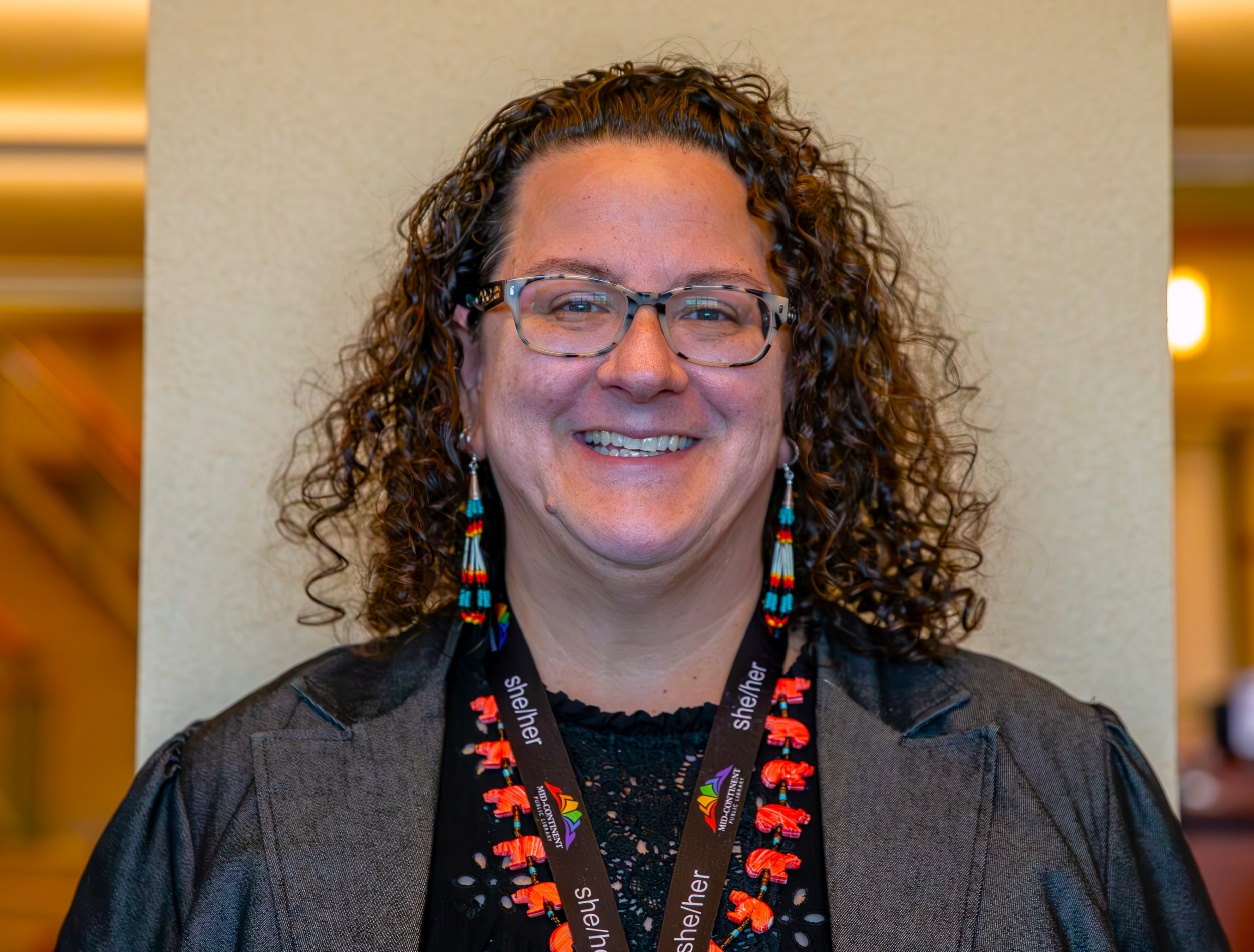 person with MCPL lanyard, earrings, and glasses