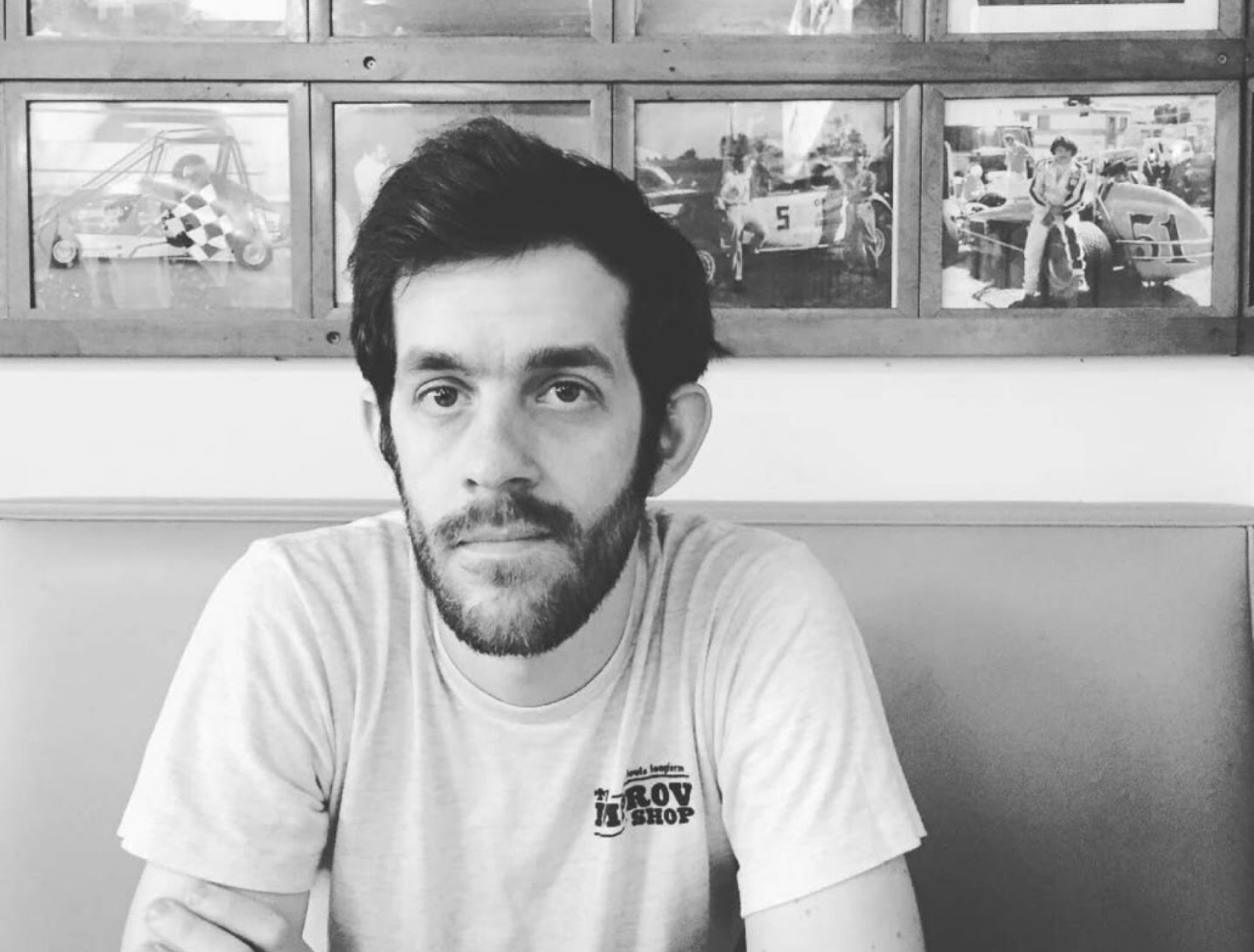 man sitting in front of framed photos