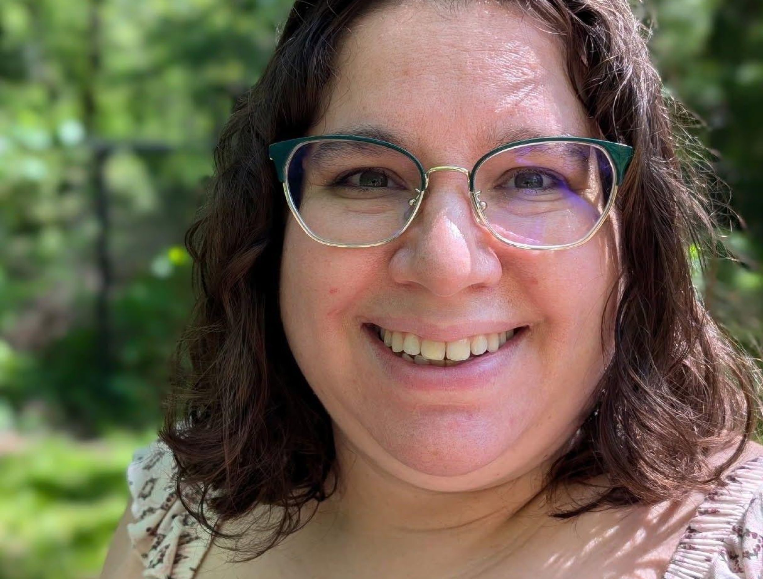 woman smiling outdoors with glasses