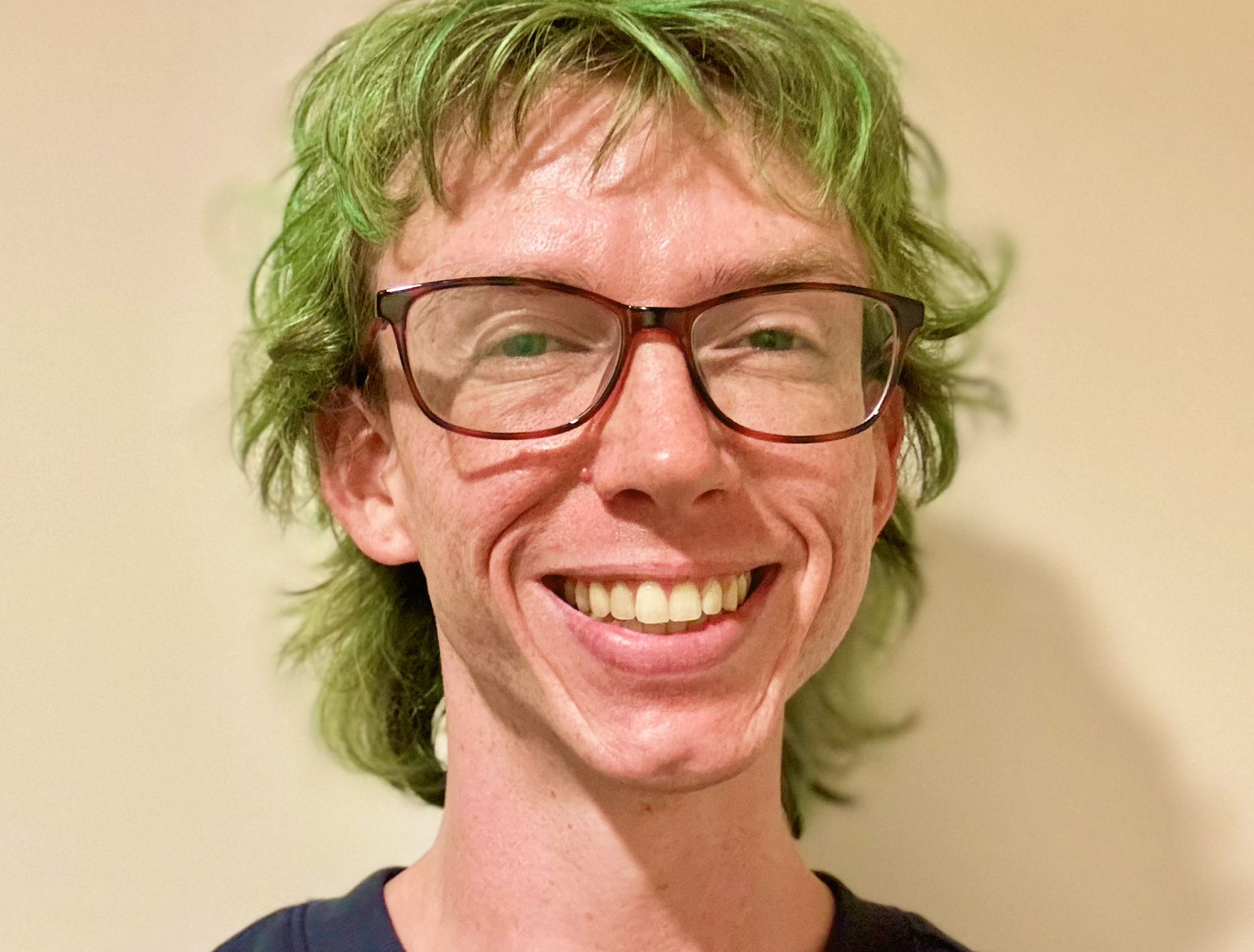 person with green hair and glasses