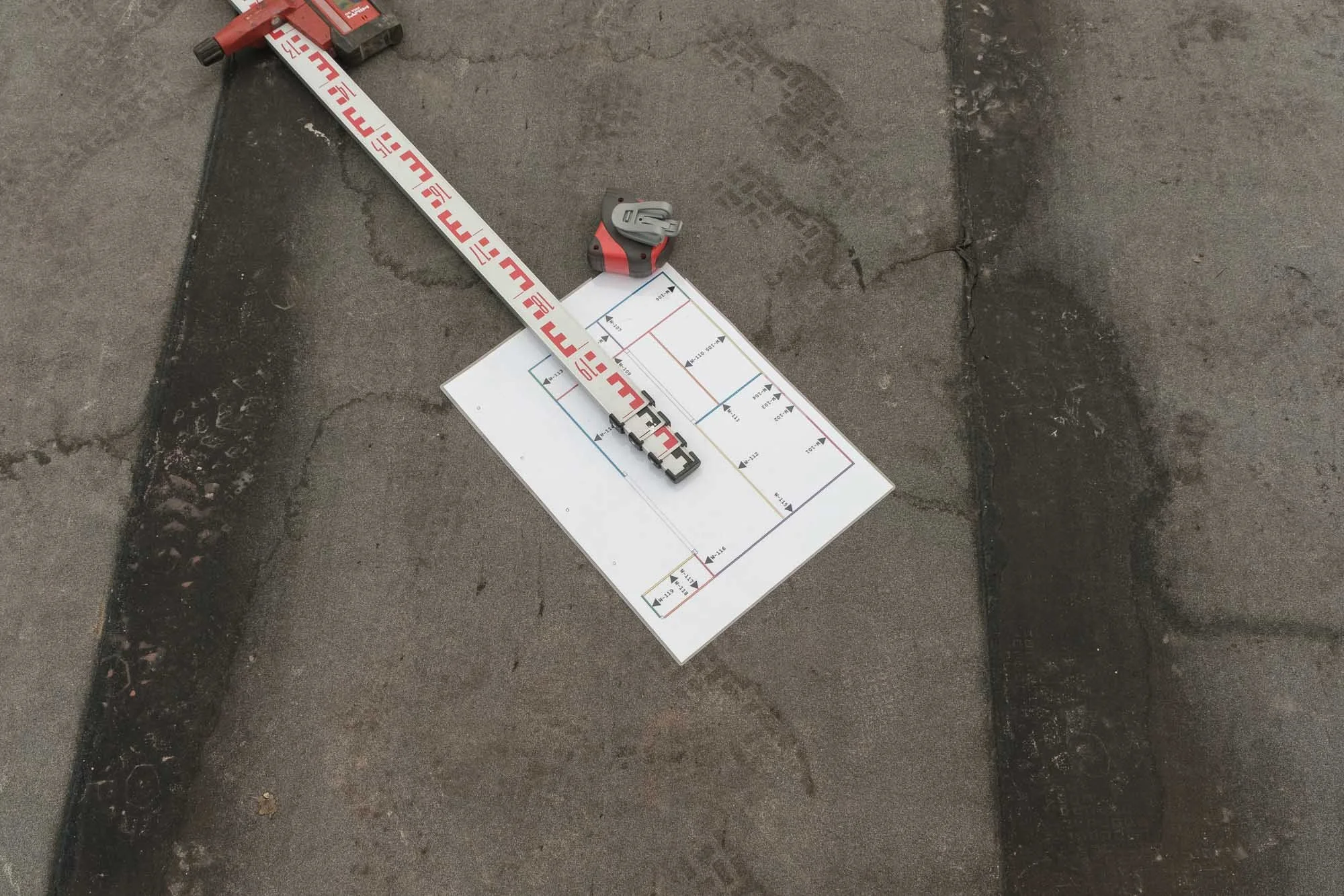 Handwerksfoto: Zollstock und Bauplan auf der Baustelle