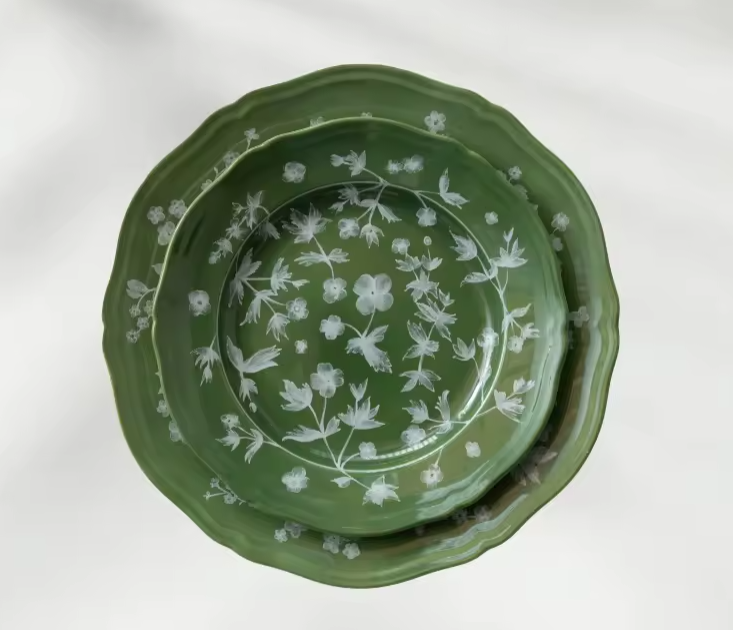 The Giardino Charger Plate features soft green tones and delicate white florals, bringing timeless garden-inspired elegance to any table setting. | Kelowna Pattern Green Charger Plate Rental