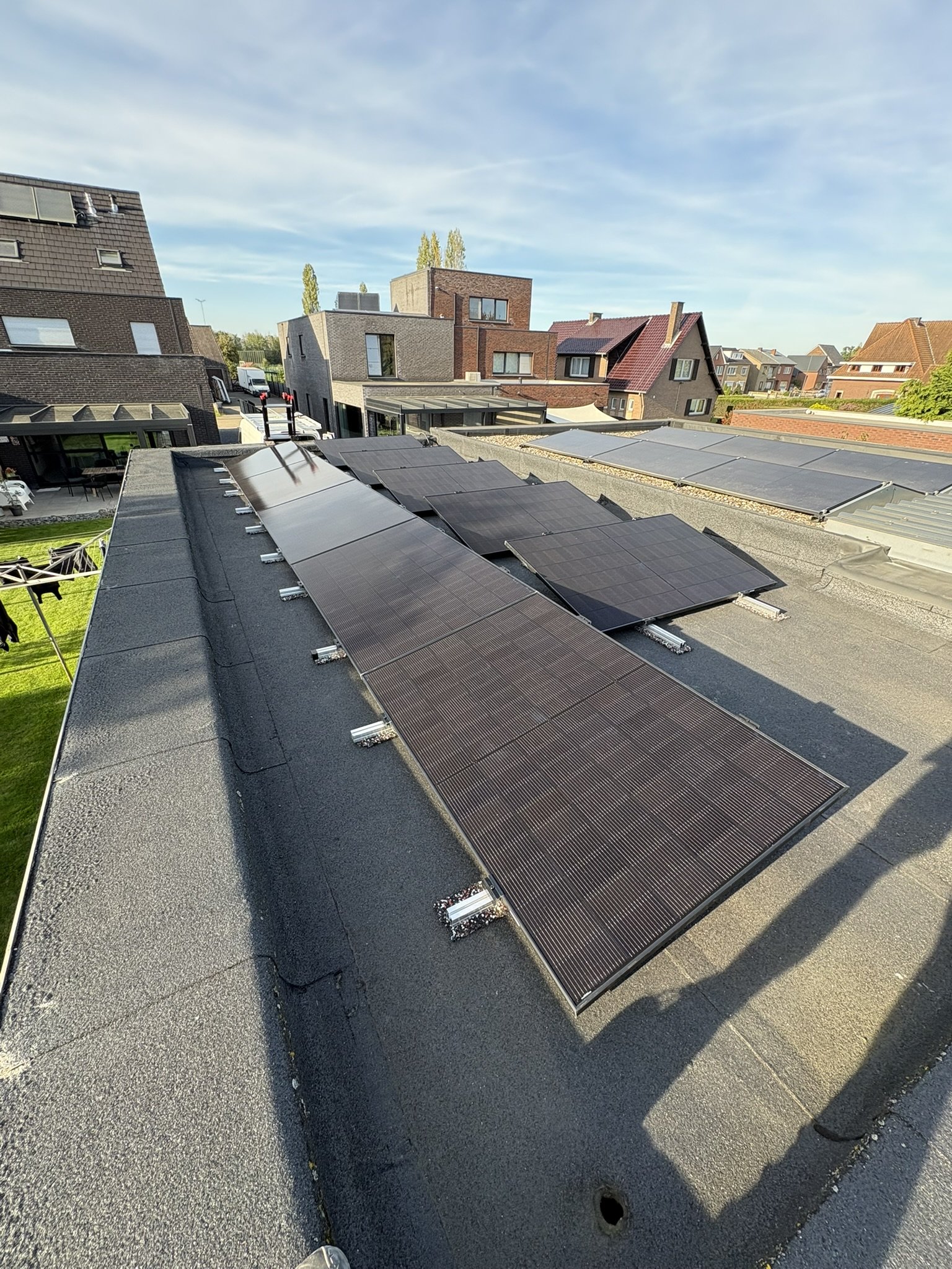 Full black zonnepanelen op plat dak bij woning