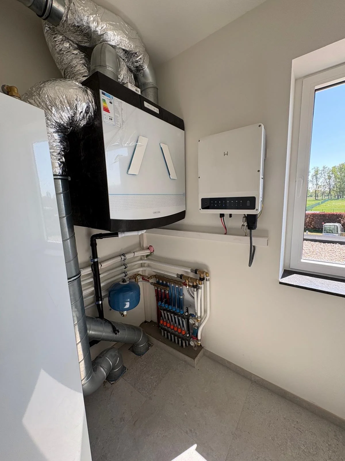 Omvormer zonnepanelen bevestigd aan muur en aangesloten met kabel