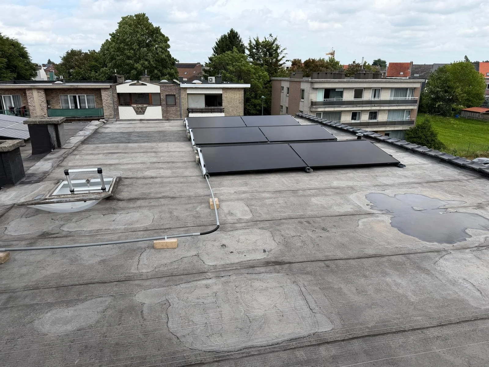 Full-black zonnepanelen op plat dak in Zemst in oost-westopstelling.
