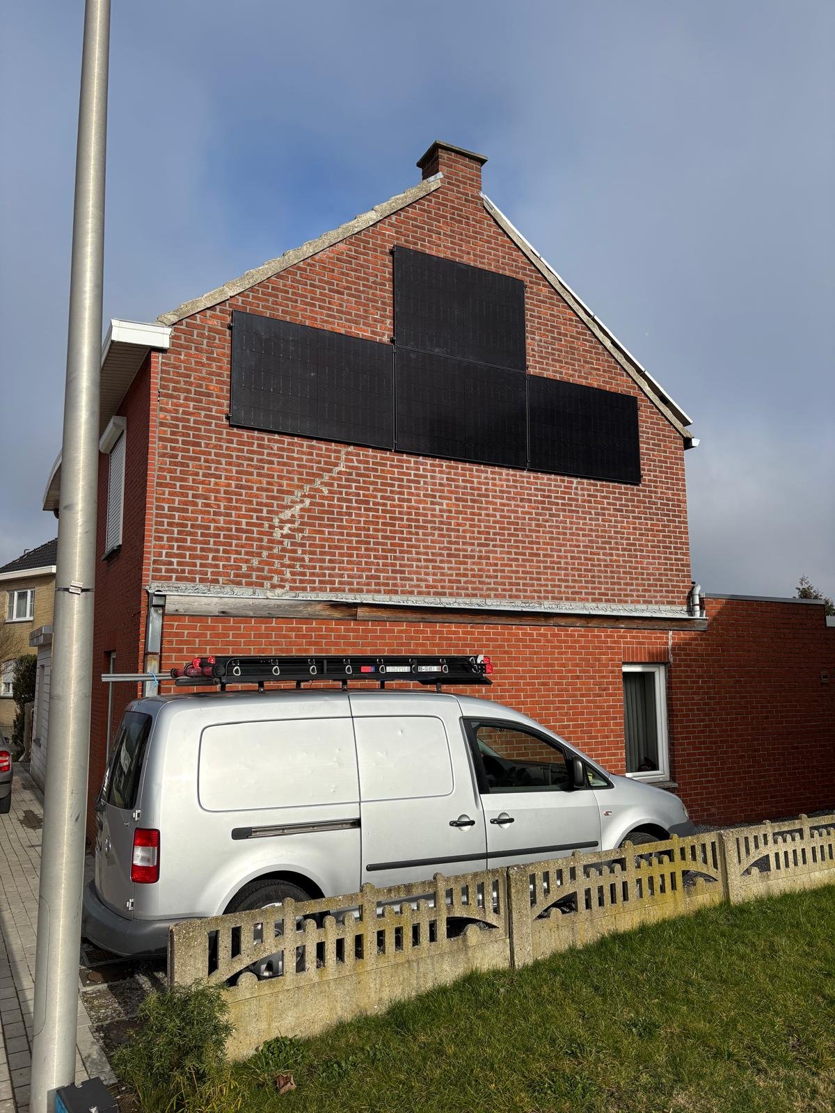 Zonnepanelen tegen bakstenen gevel in Oudsbergen
