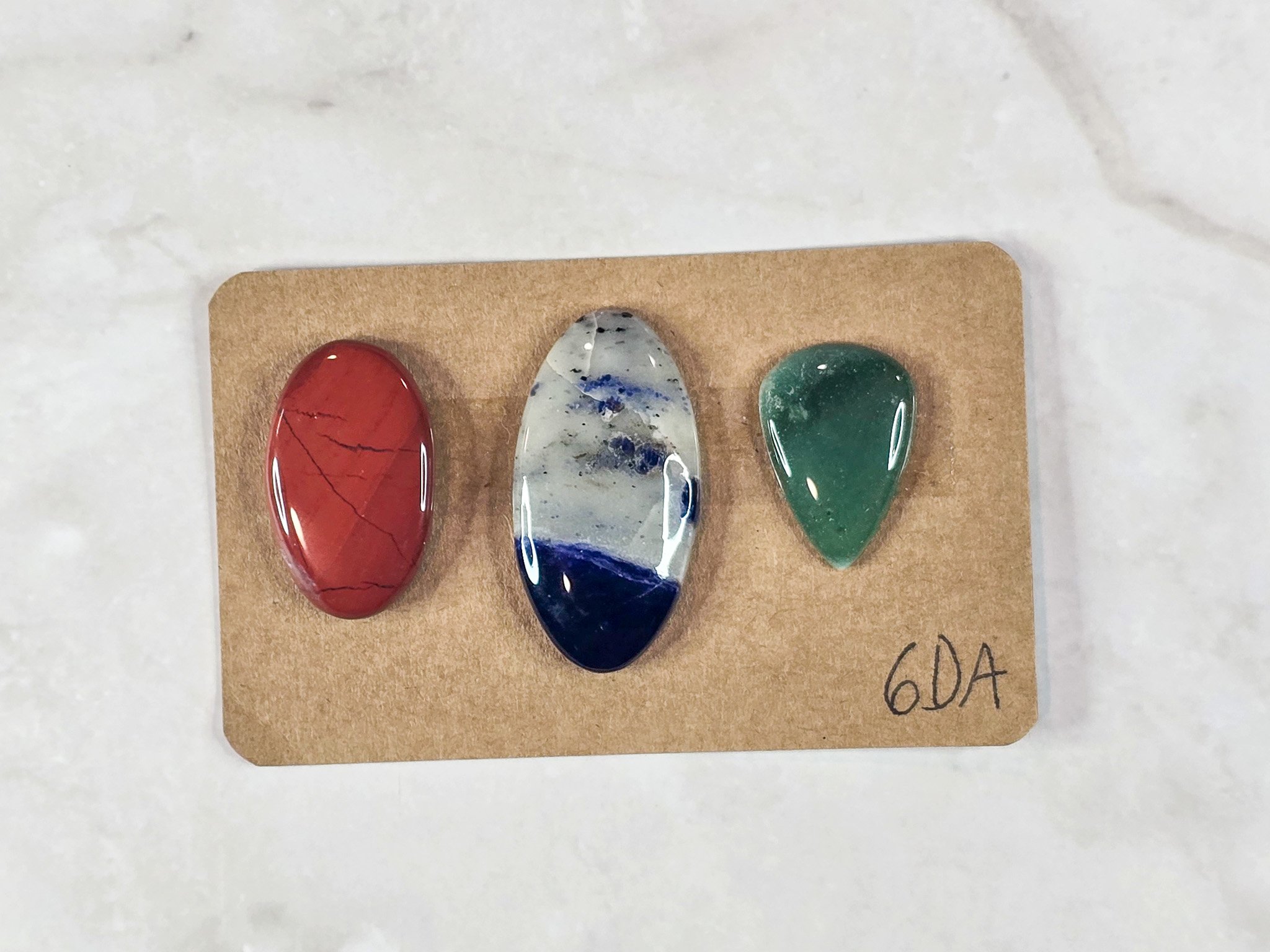 Mixed cabochon parcel including green aventurine, sodalite, and red jasper.