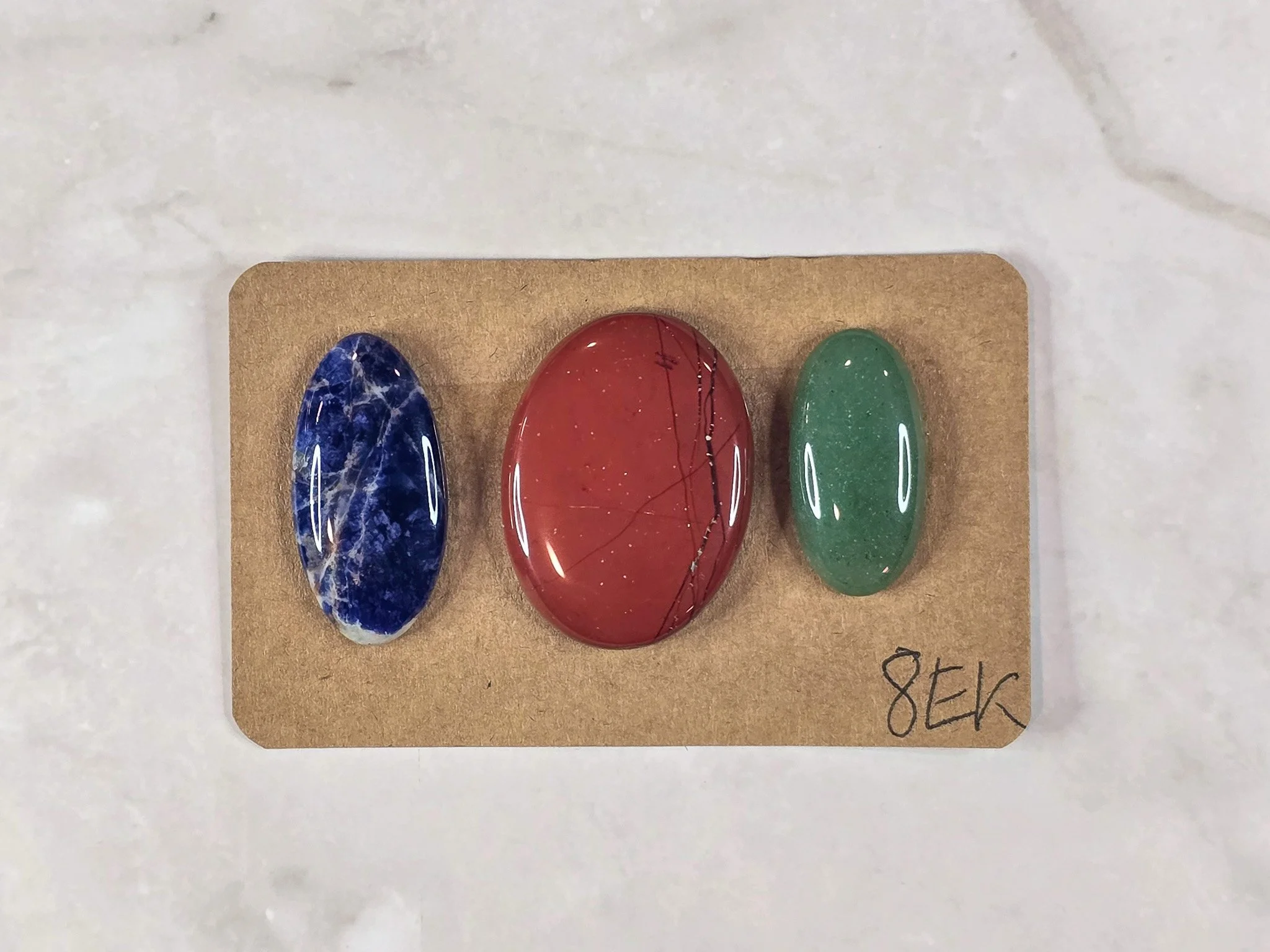 Mixed cabochon parcel including green aventurine, sodalite, and red jasper.