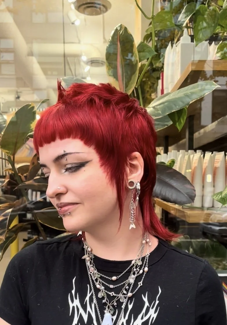 Choppy red mullet with blunt micro bangs and wispy layers, one of Meg’s haircuts in the University District at Lady Neptune