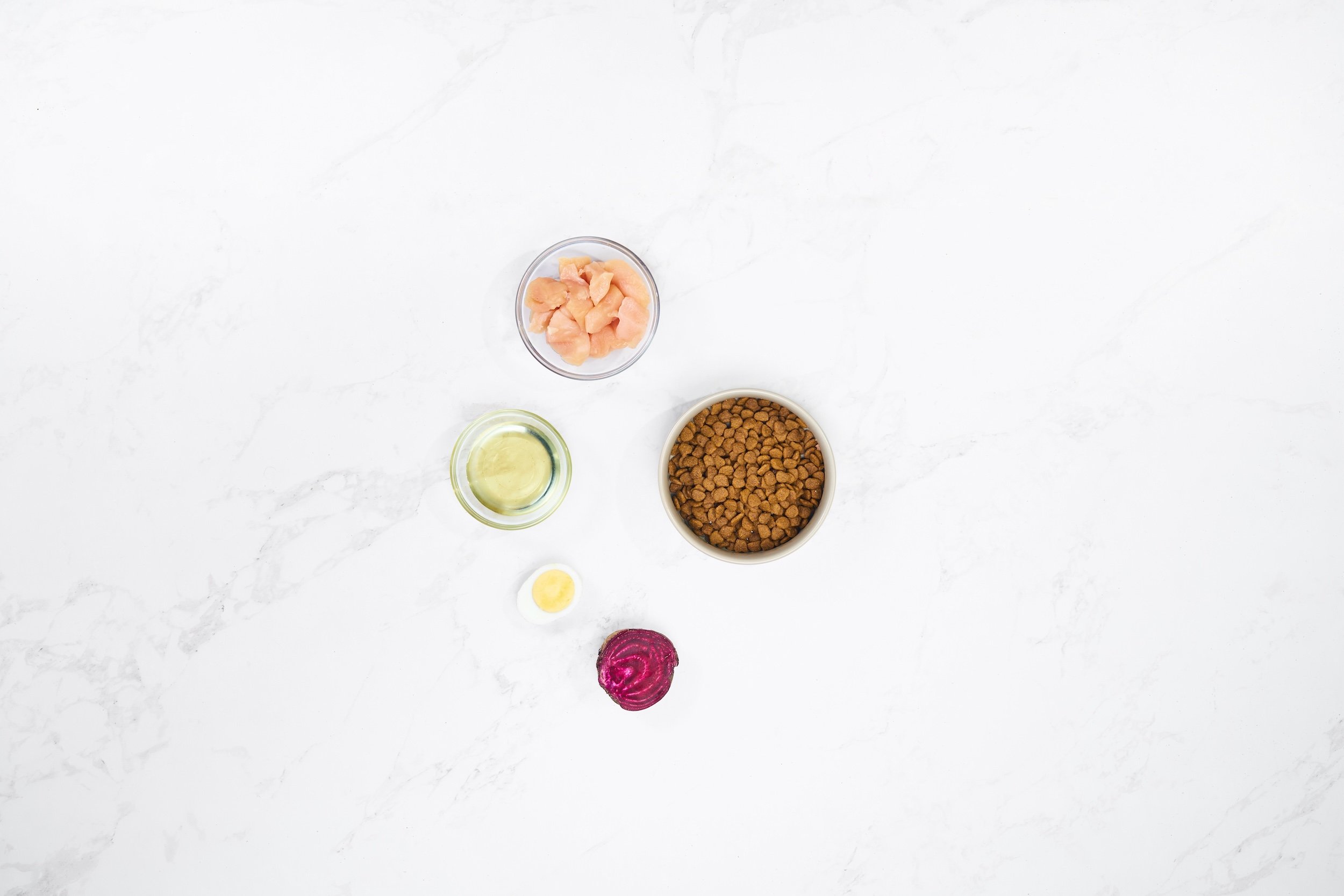Flat Lay product photography of a bowl of dog food and ingredients on a marble background