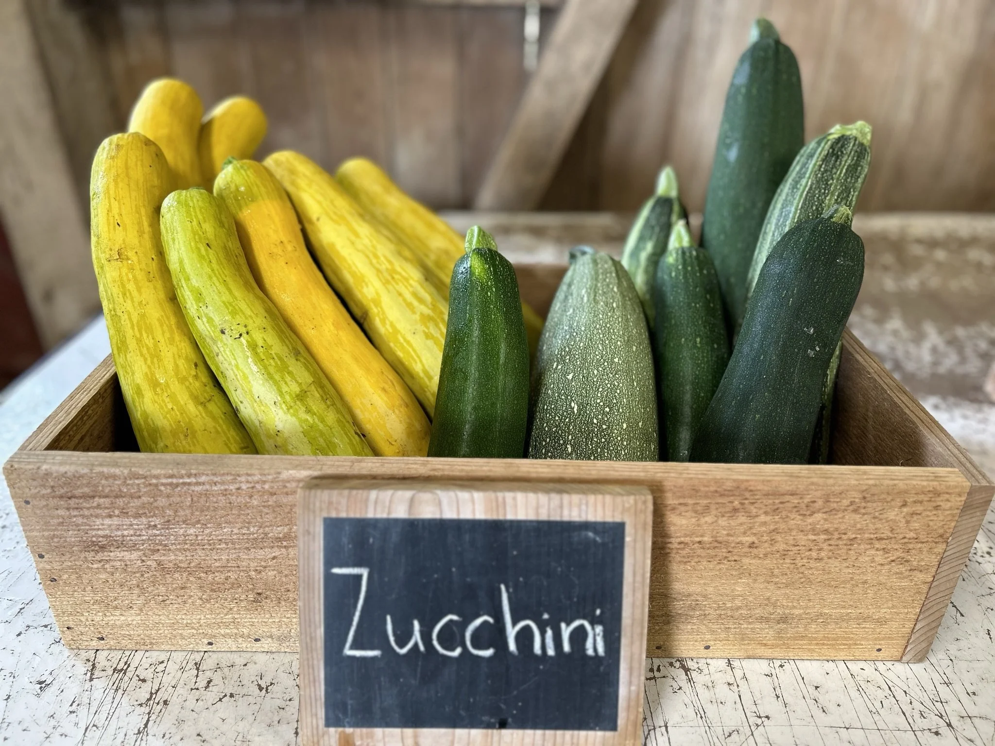 A box full of yellow squash and green zucchini