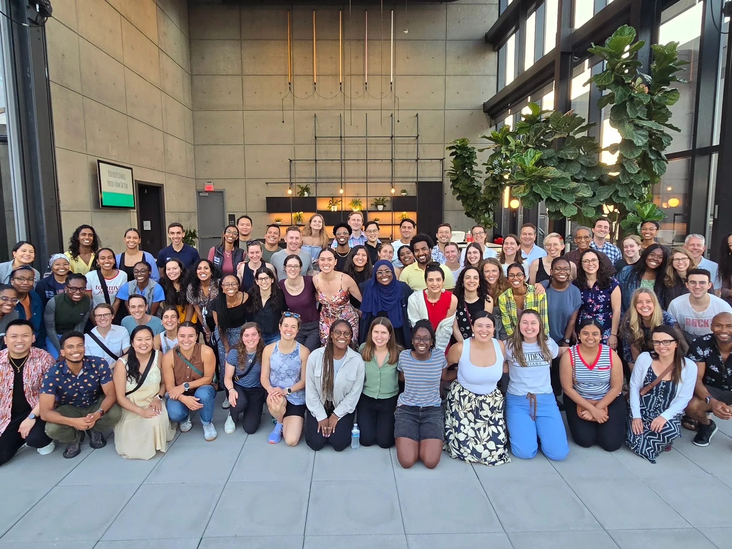 A large group of residents sitting outside a balcony.