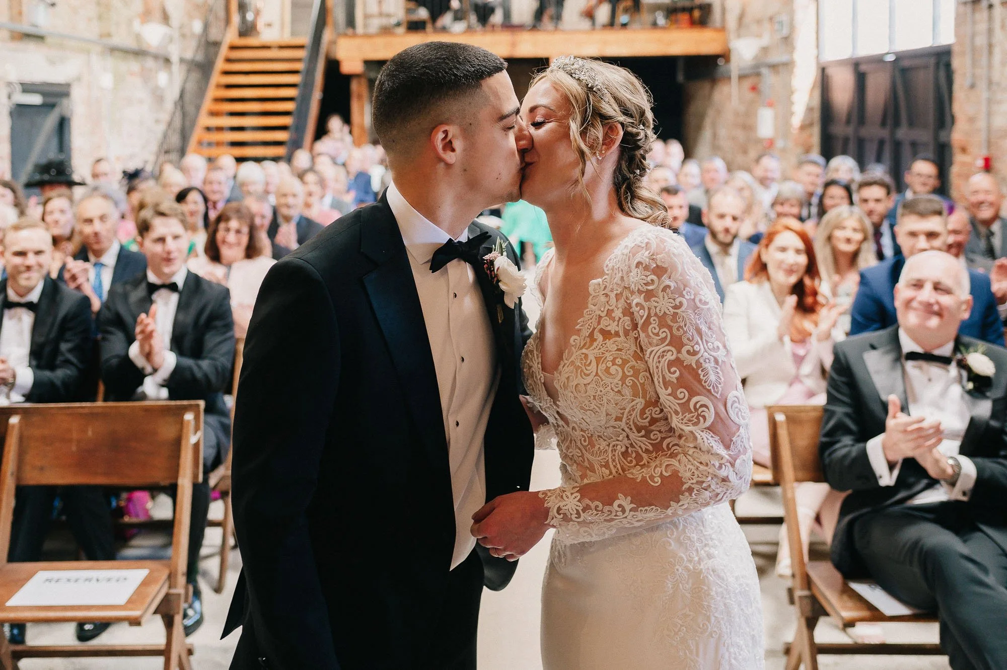 The bride and groom sharing their first kiss as newly weds in The Oakley Barn.