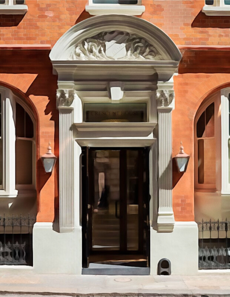 The entrance to Crescent House features a black doorway framed by white classical columns with ornate capitals, topped with a semi-circular decorative arch and a black and white sign that reads 'Crescent House'.