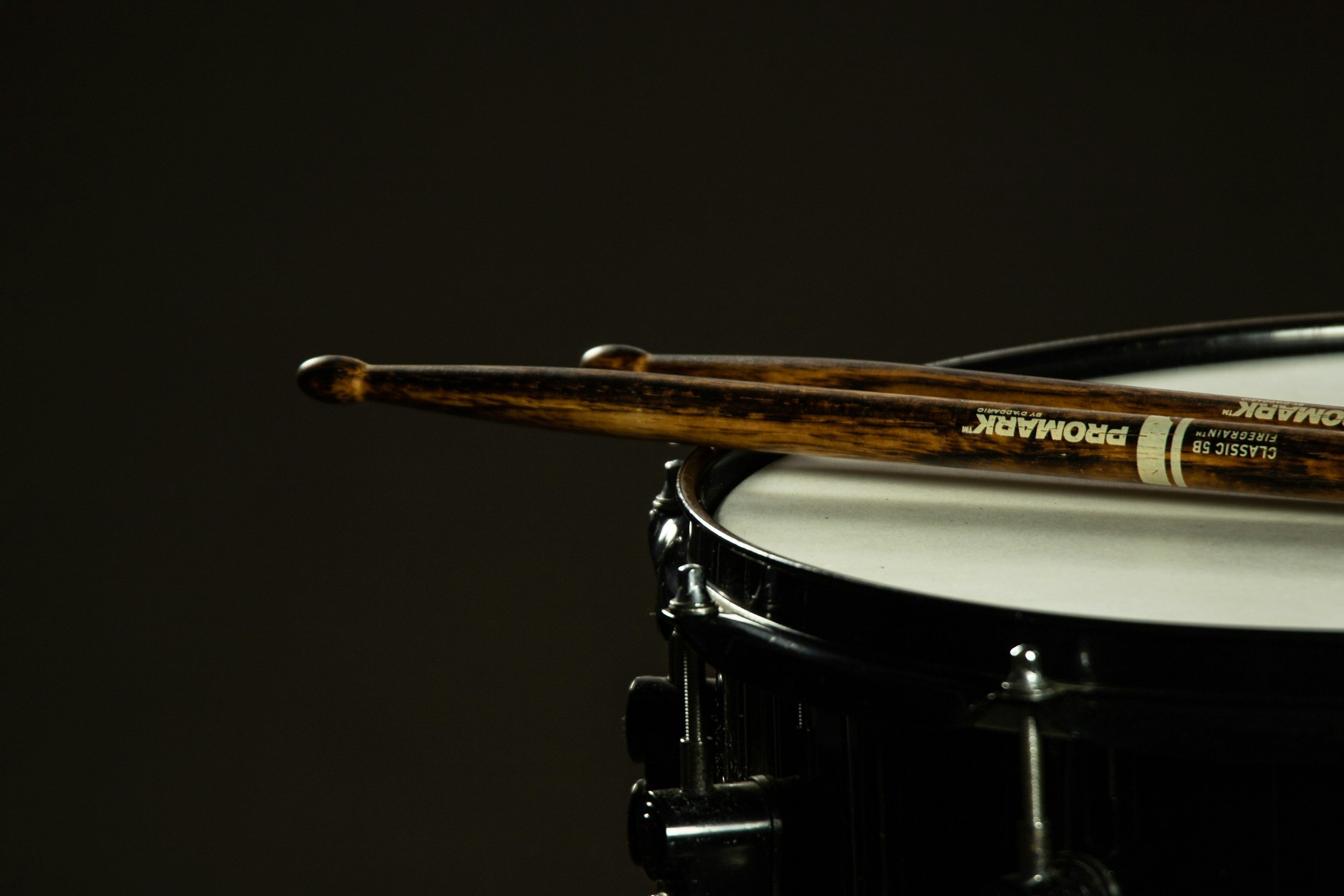 Close-up of drum sticks lying a top of a drum.