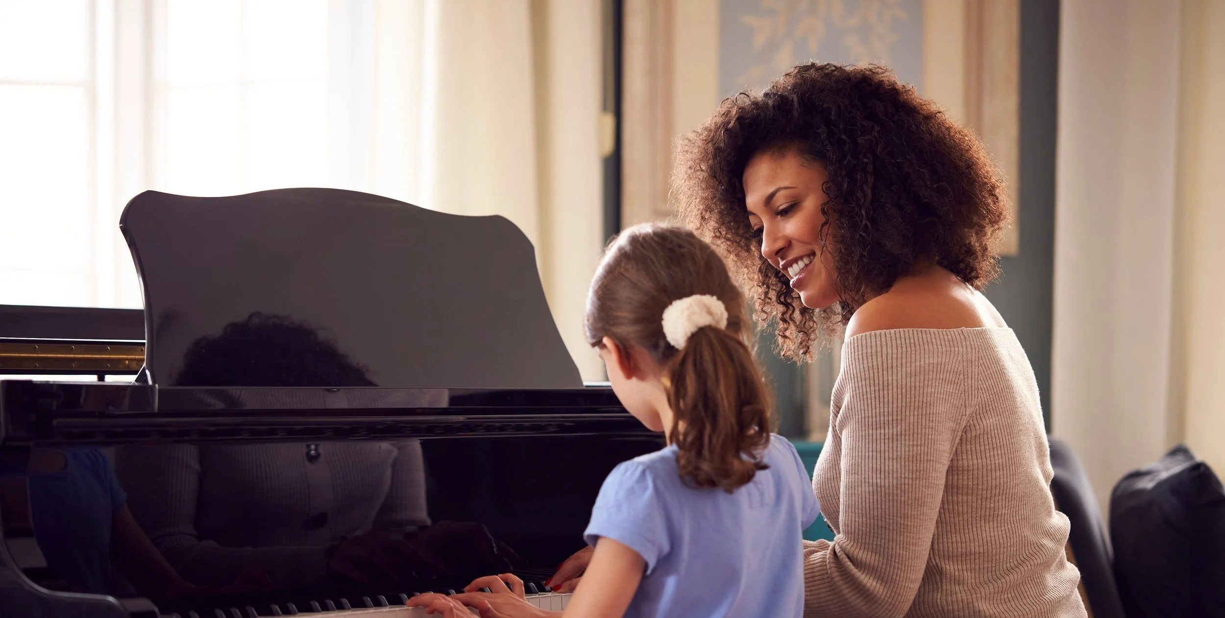 A teacher and student enjoying a private music lesson at home in London.