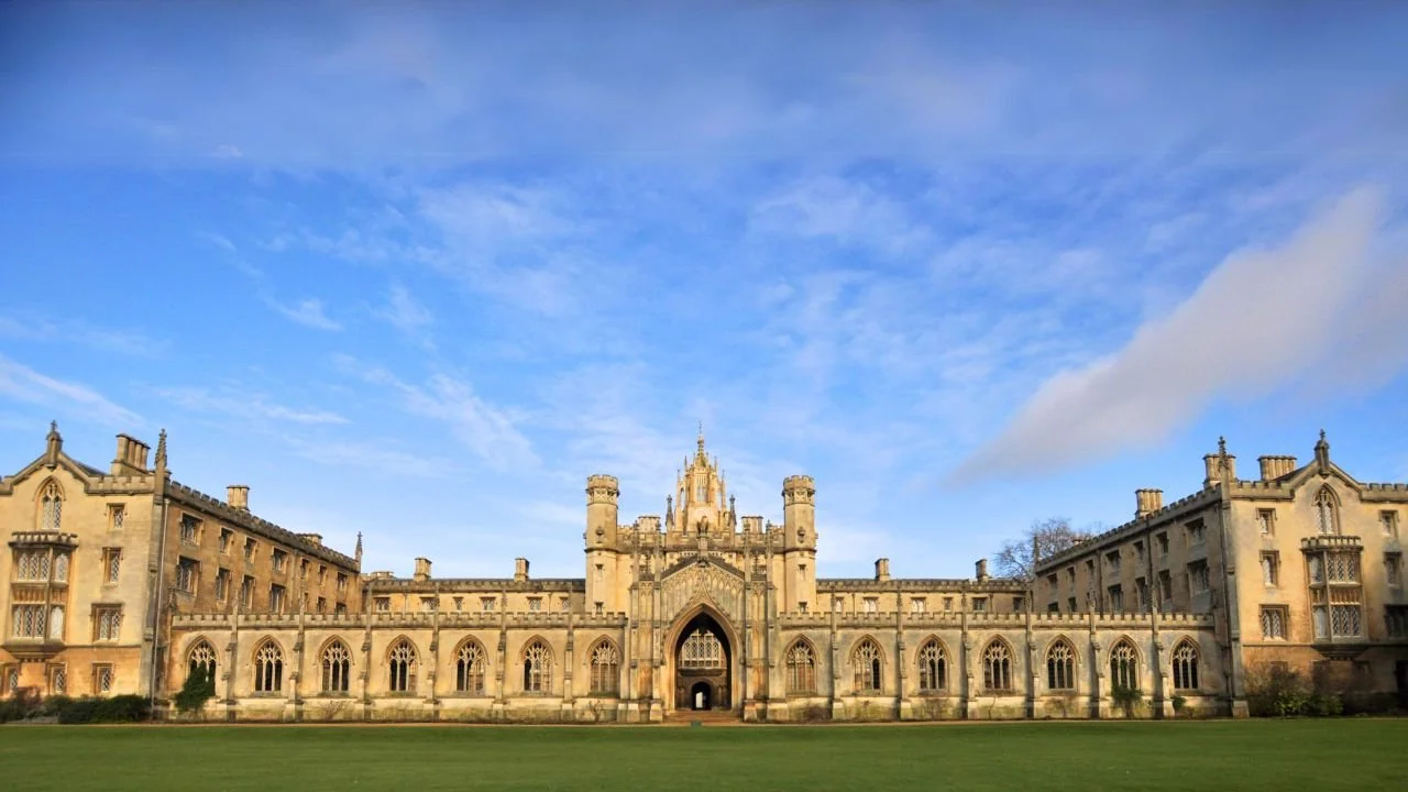 Historic music school in London surrounded by green fields and blue skies.