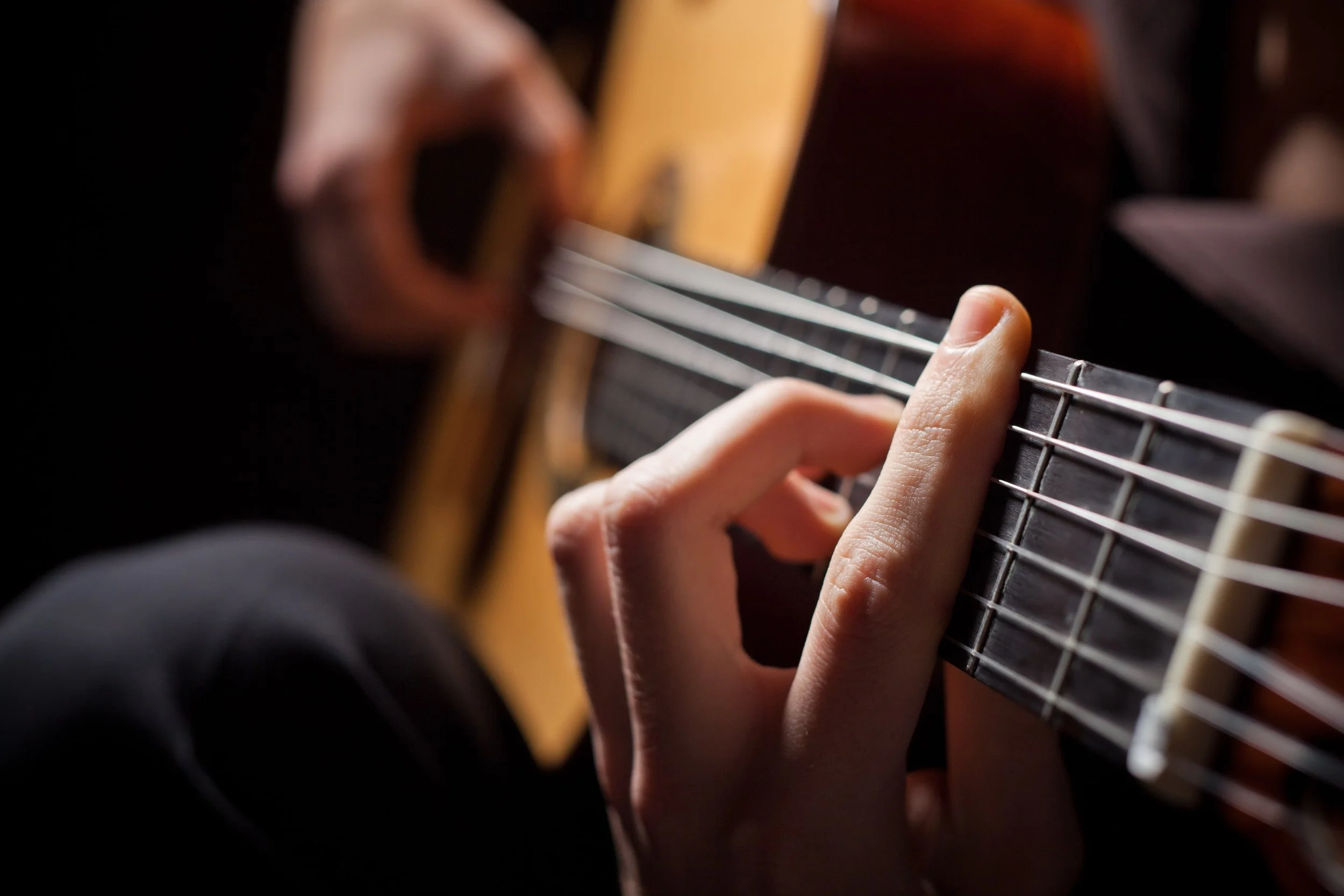 A close-up of hands playing the guitar in London.