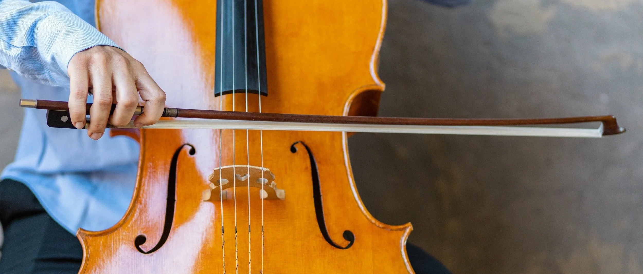 Child playing cello in school uniform.