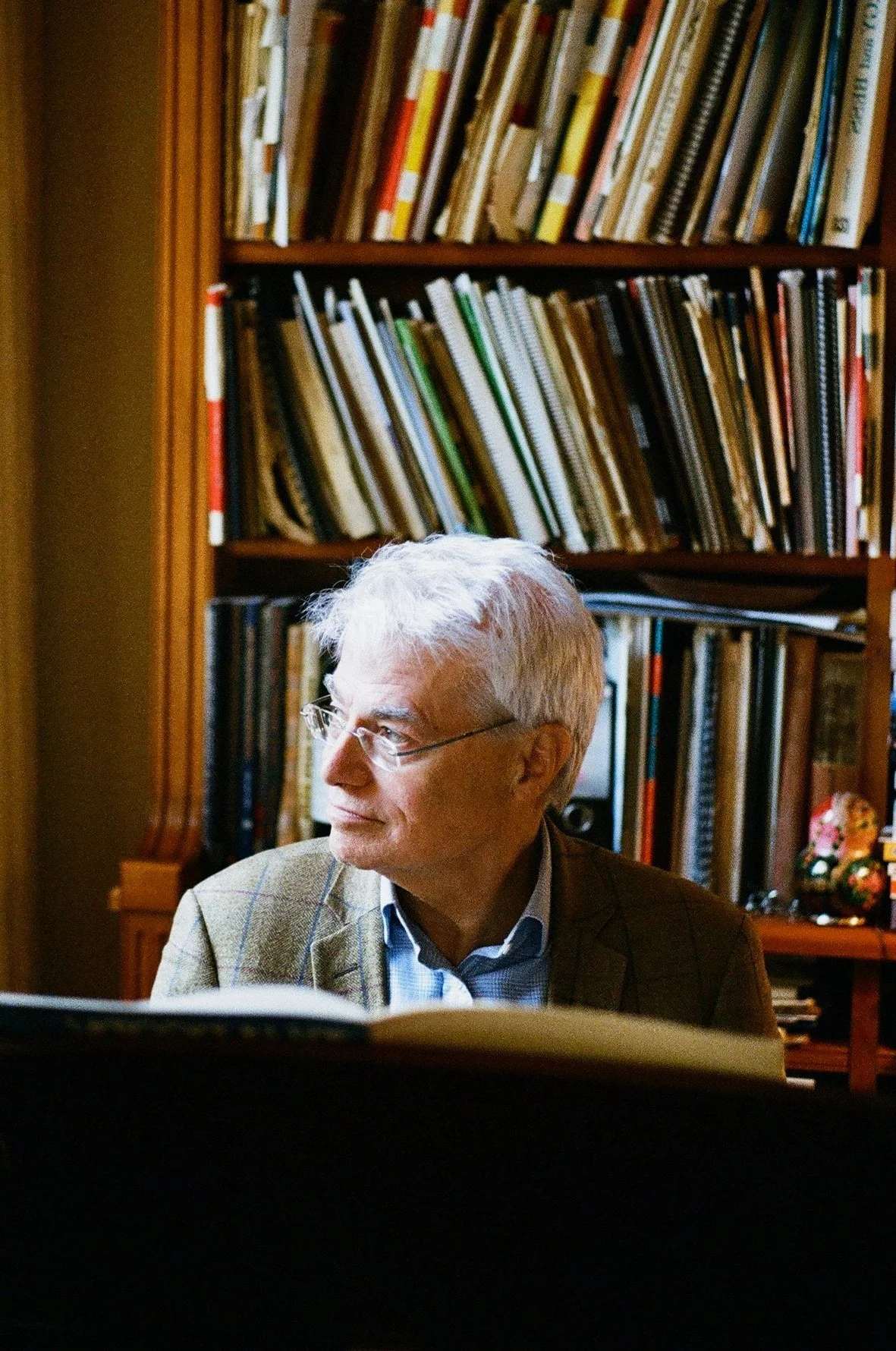 Ralph Alwood sat in front of books on a bookshelf.