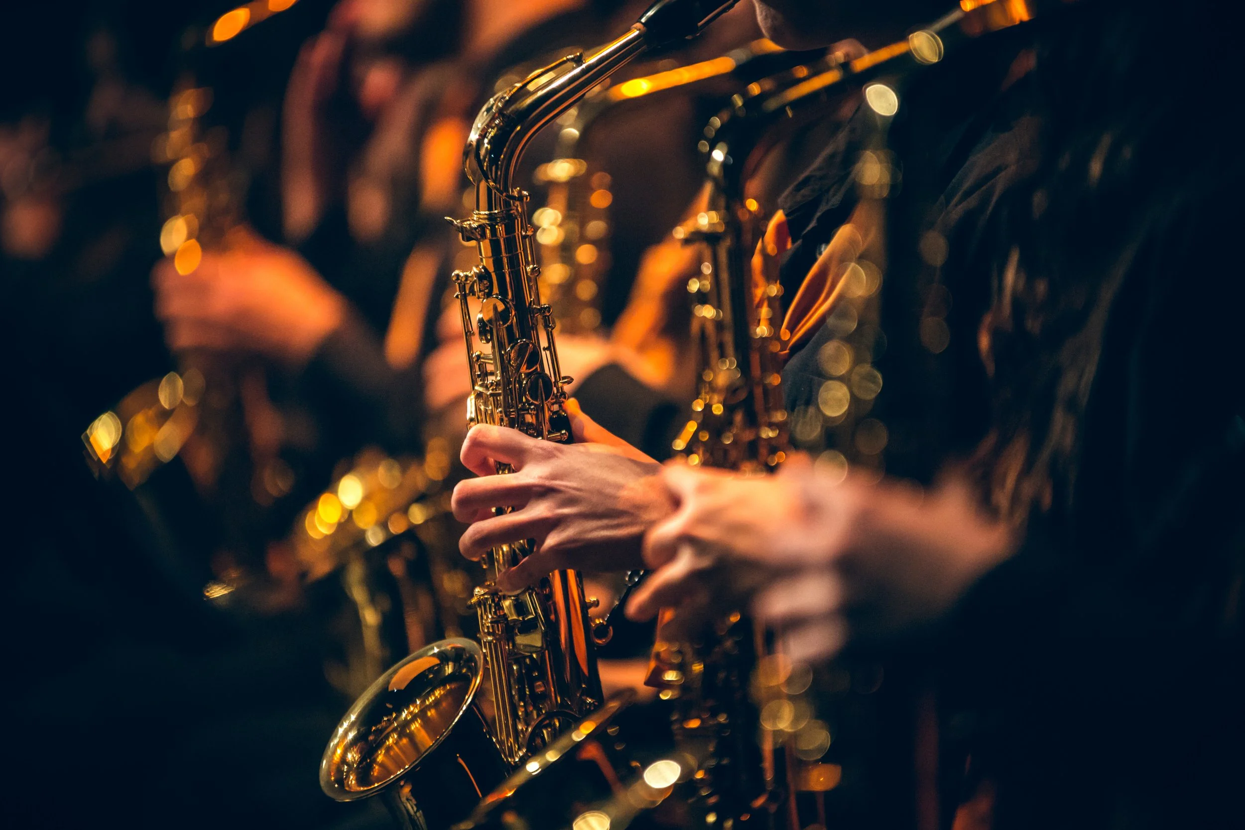 Close-up of the saxophone section in an adult orchestra.