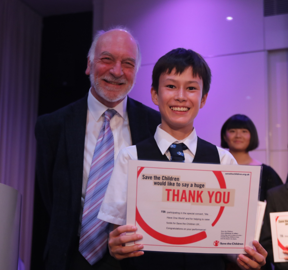 Student receiving an award certificate from music teacher.