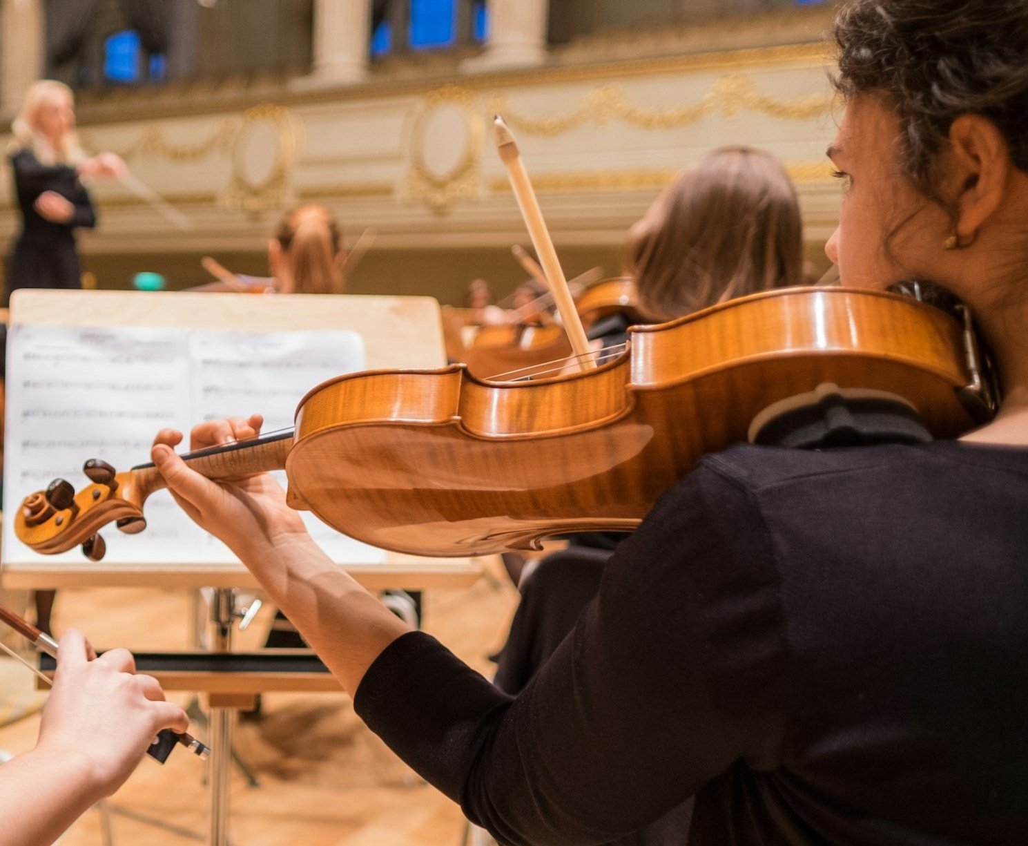 A close-up of a young girl playing the viola in an orchestra in London.