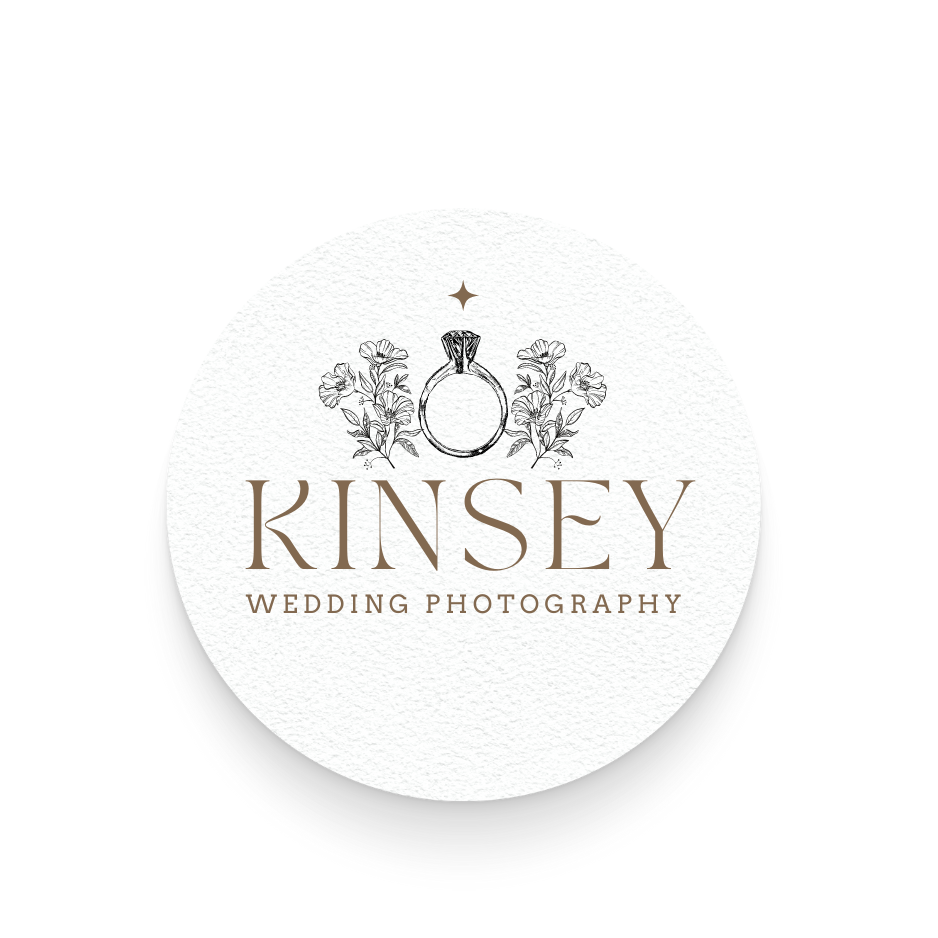 A logo for Kinsey Wedding Photography featuring a hand-drawn engagement ring surrounded by sprigs of flowers, with a small star above and the name 'Kinsey' below, on a white circular background.