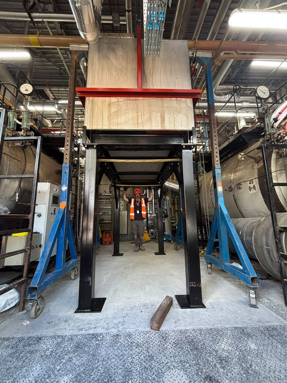 CIS supporting the installation of pharmaceutical processing equipment, team member under large piece of equipment