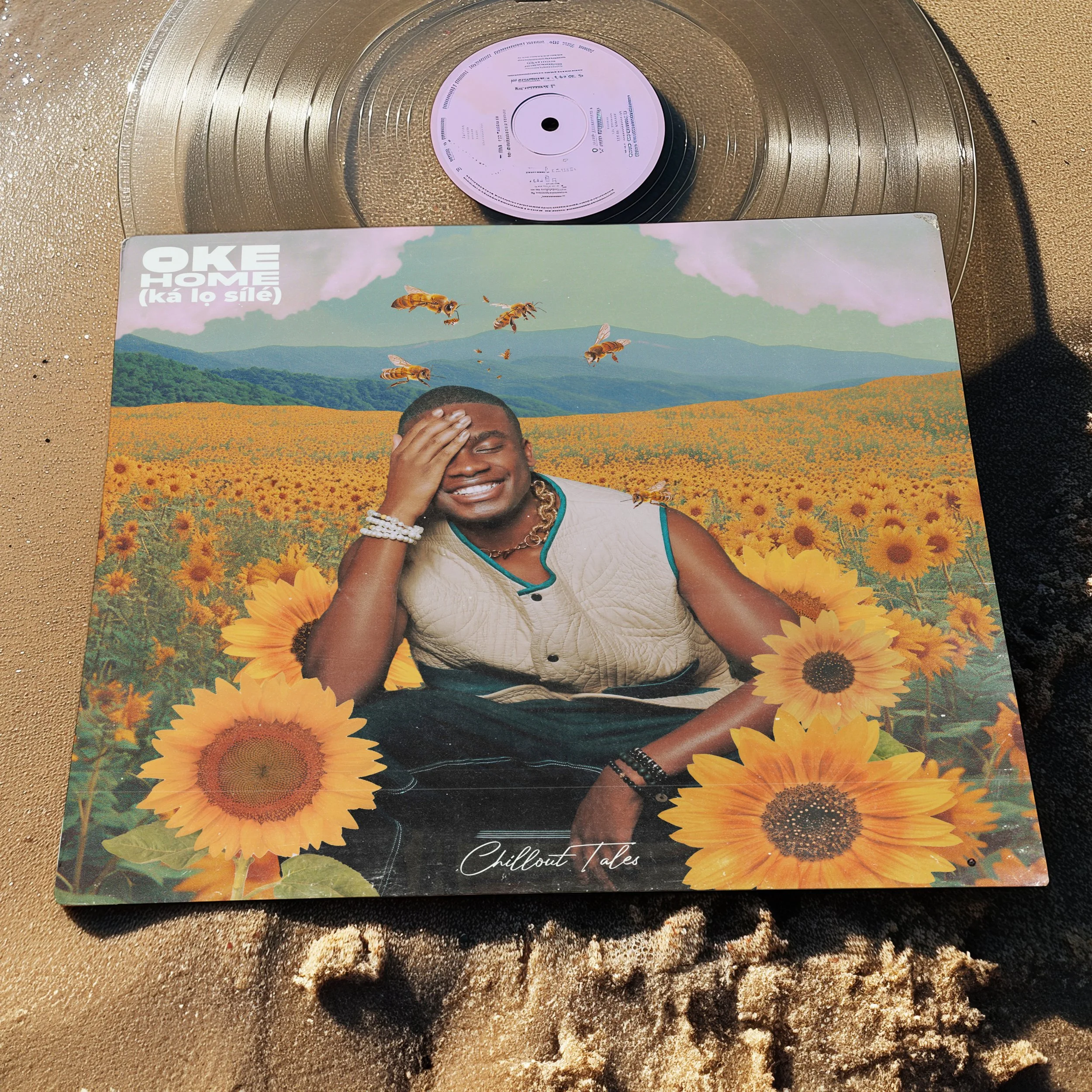 A vinyl record with a colorful album cover featuring a person smiling and resting their head in a sunflower field, with bees and a mountain landscape in the background.