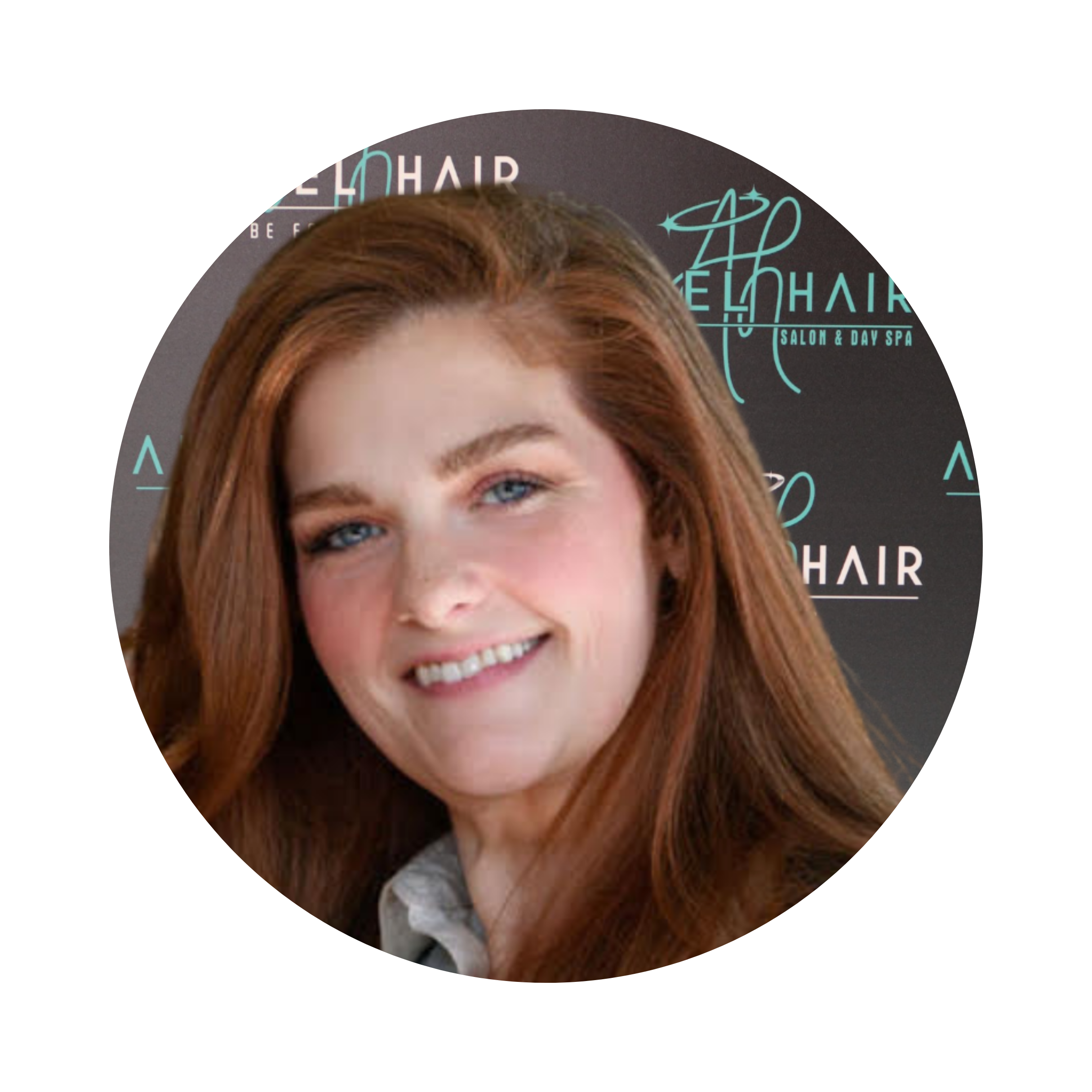 Woman with long red hair smiling, in front of a backdrop with salon branding that reads 'Evo Hair' and 'Salon & Day Spa'.