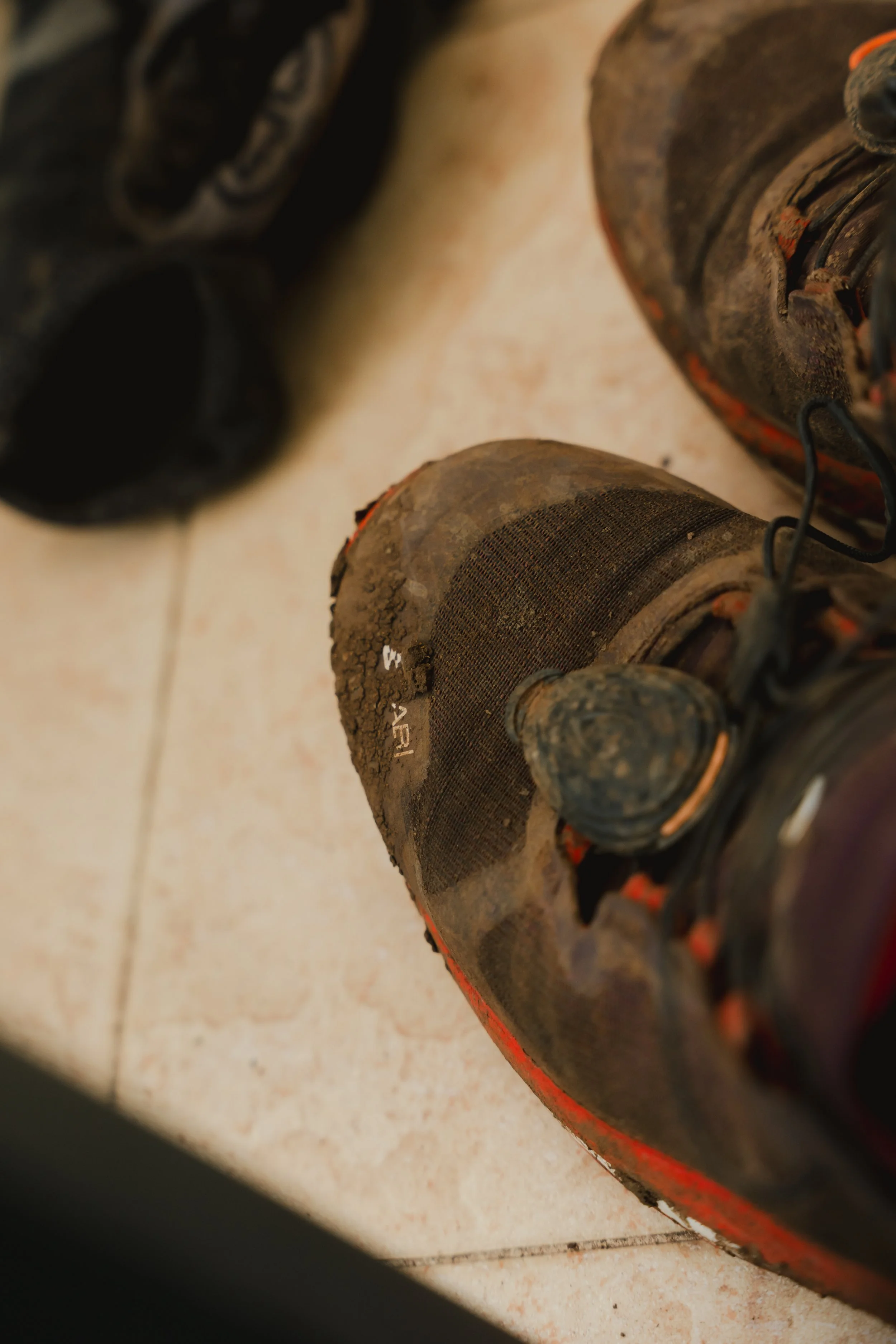 Dreckige, alte Laufschuhe auf Steinboden